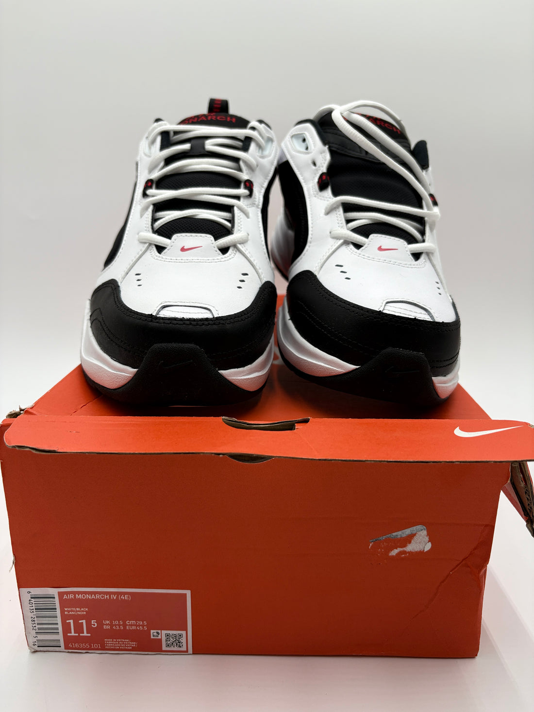 Black and white athletic shoes on a Nike box with a gray background