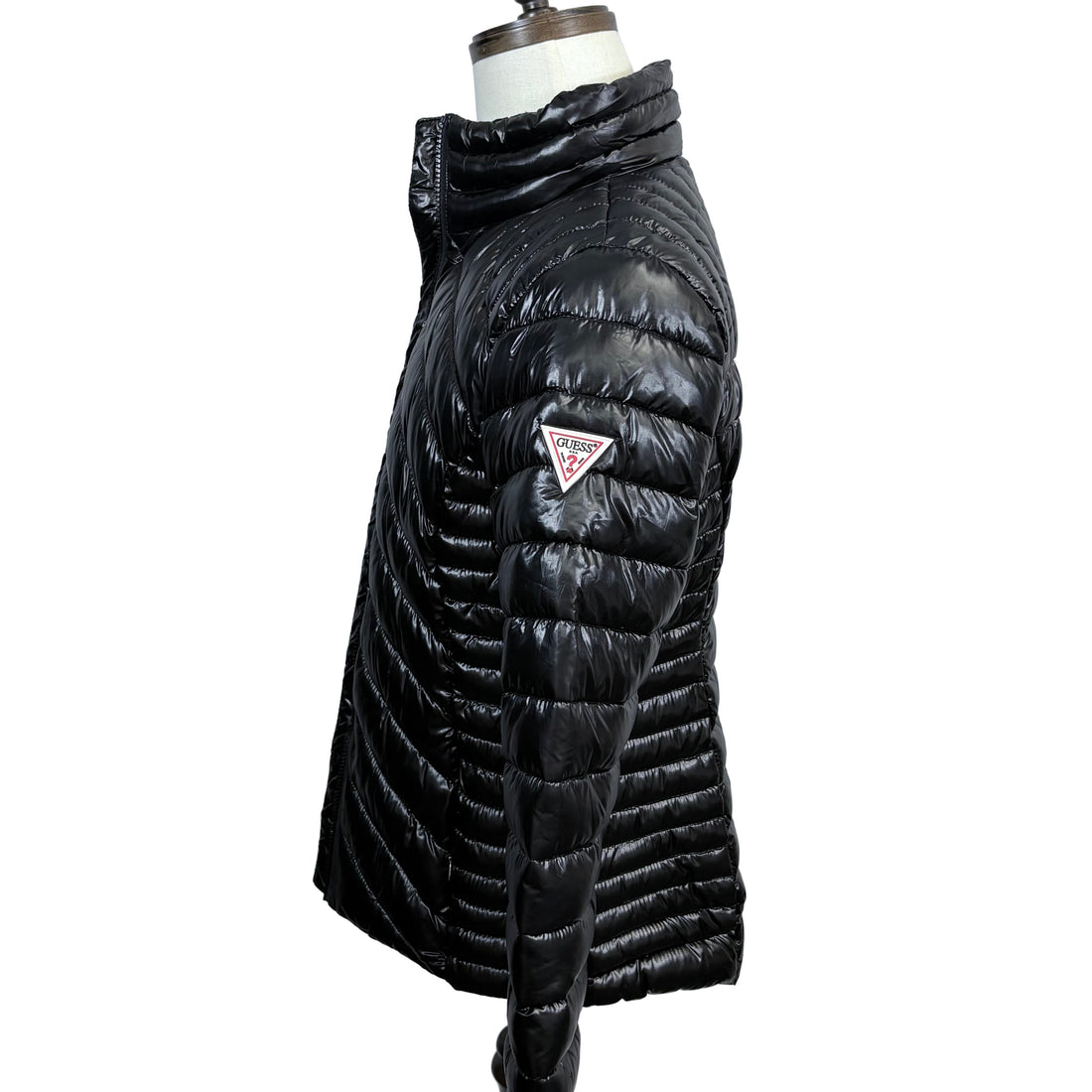 Black puffer jacket on a mannequin against a white background