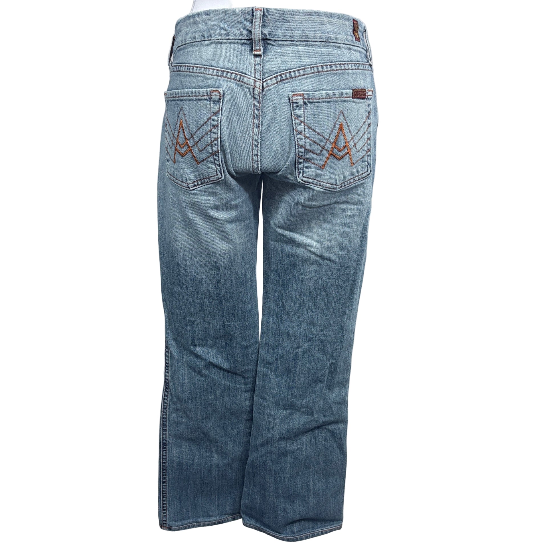 Blue jeans with a visible brand logo on the back pocket against a white background