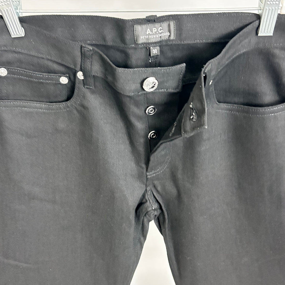 Black pants with visible A.P.C. label on a white background