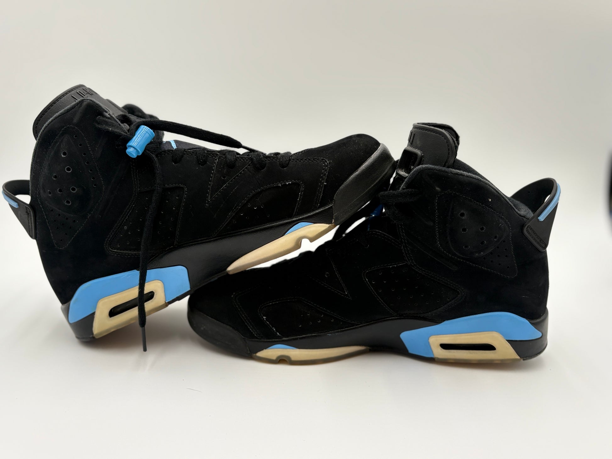 Pair of black sneakers with blue and beige accents on a white background