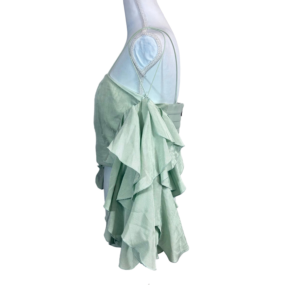 Light green top with ruffled sleeves on a mannequin against a white background