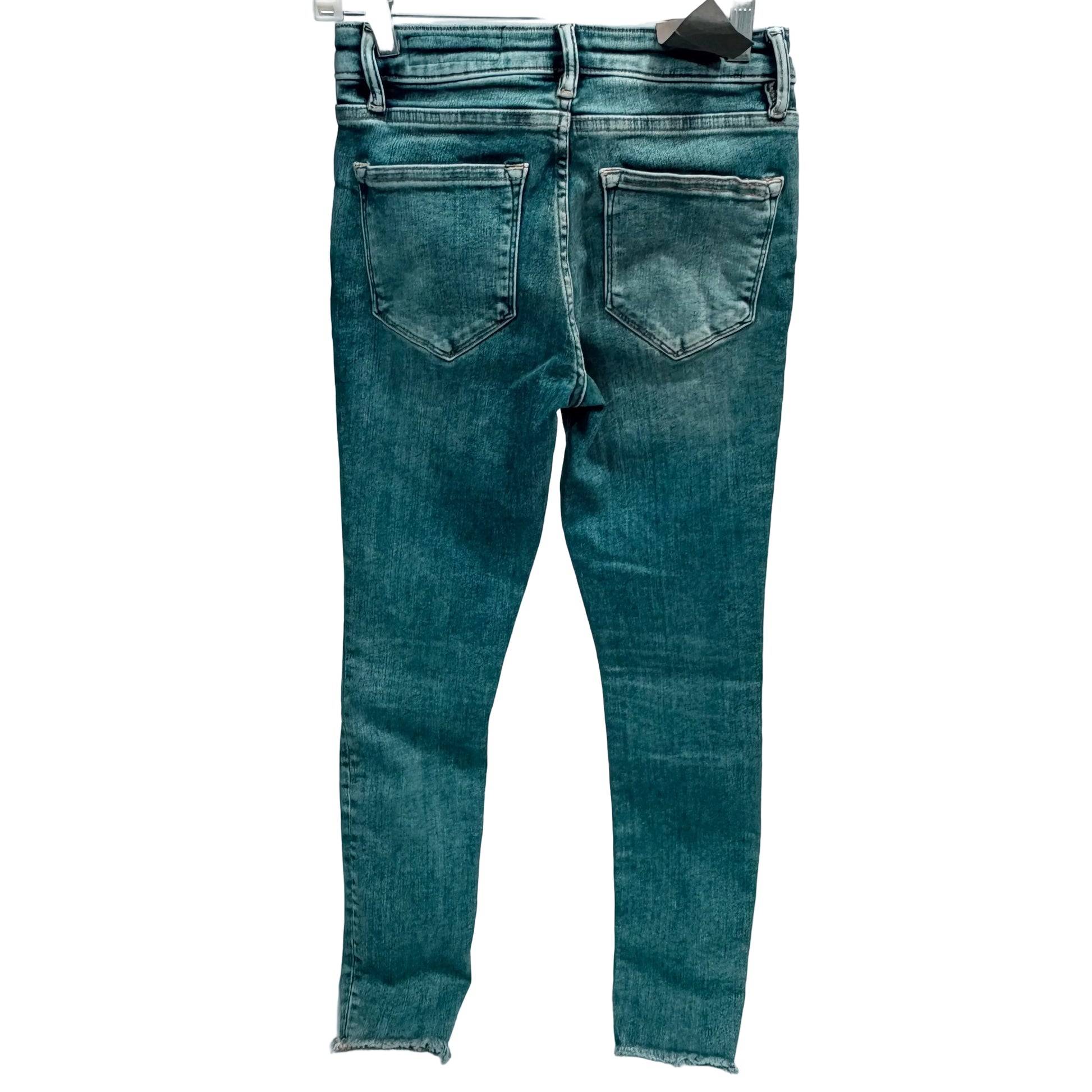 Blue jeans on a hanger against a white background