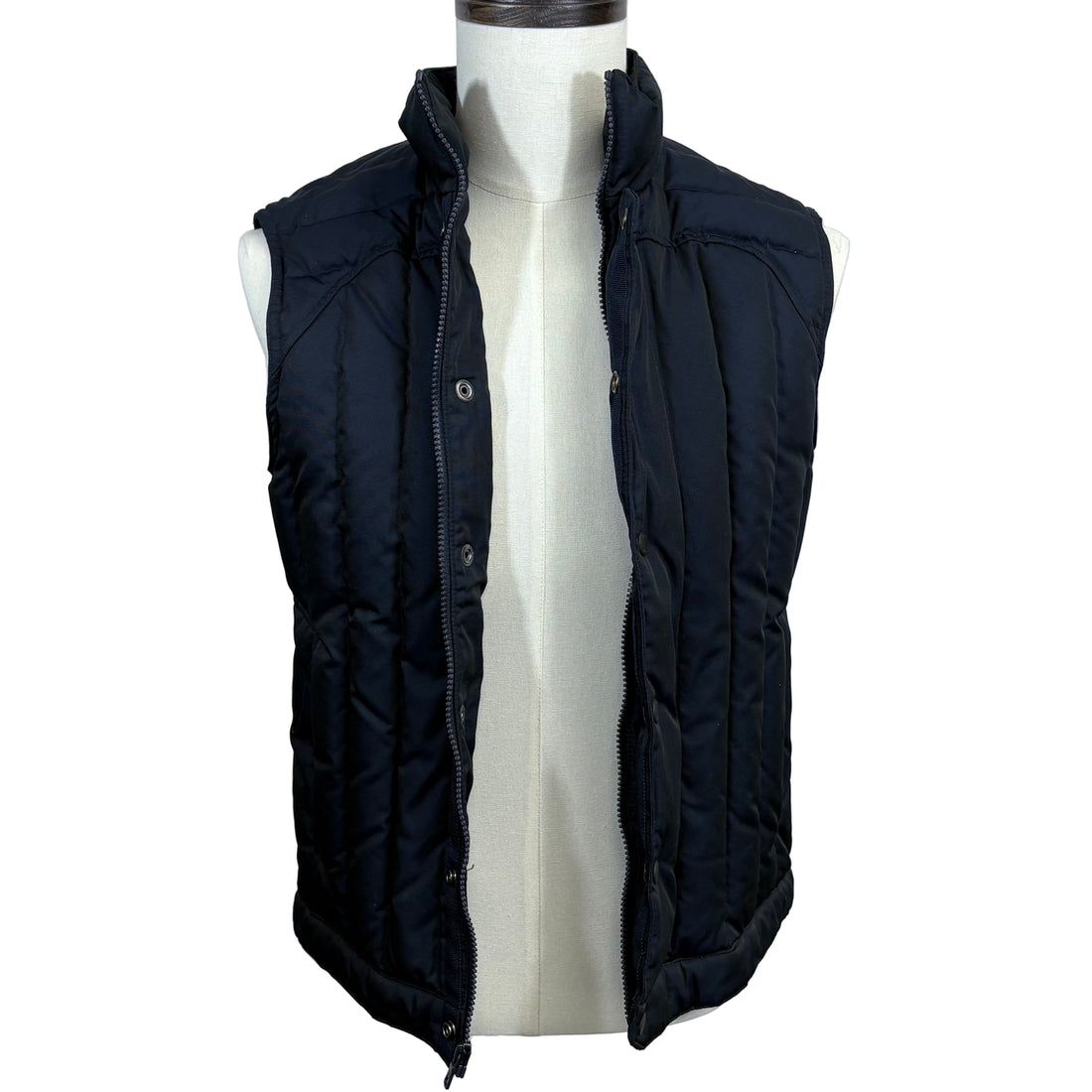 Black puffer vest on a mannequin against a plain background