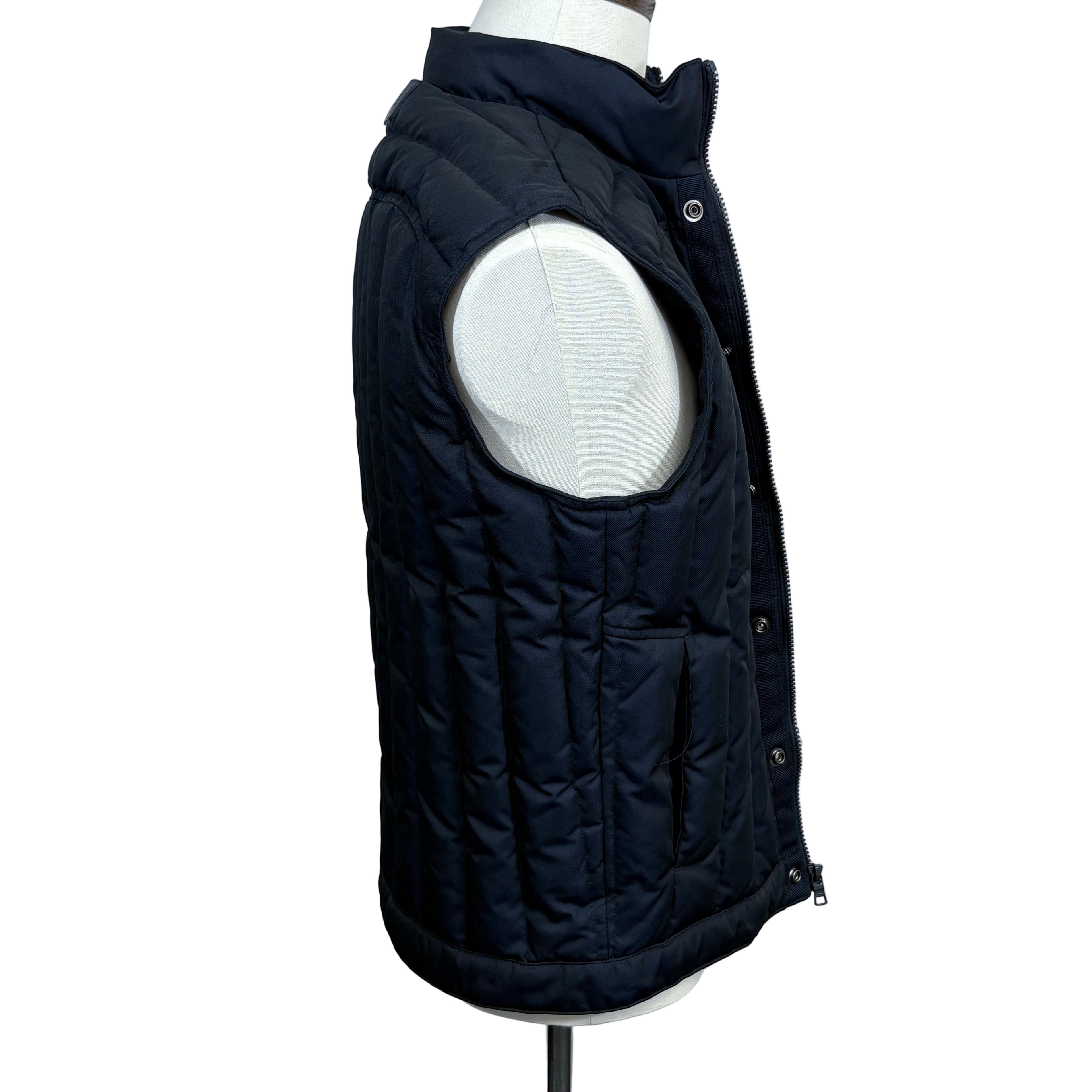Black puffer vest on a mannequin against a gray background