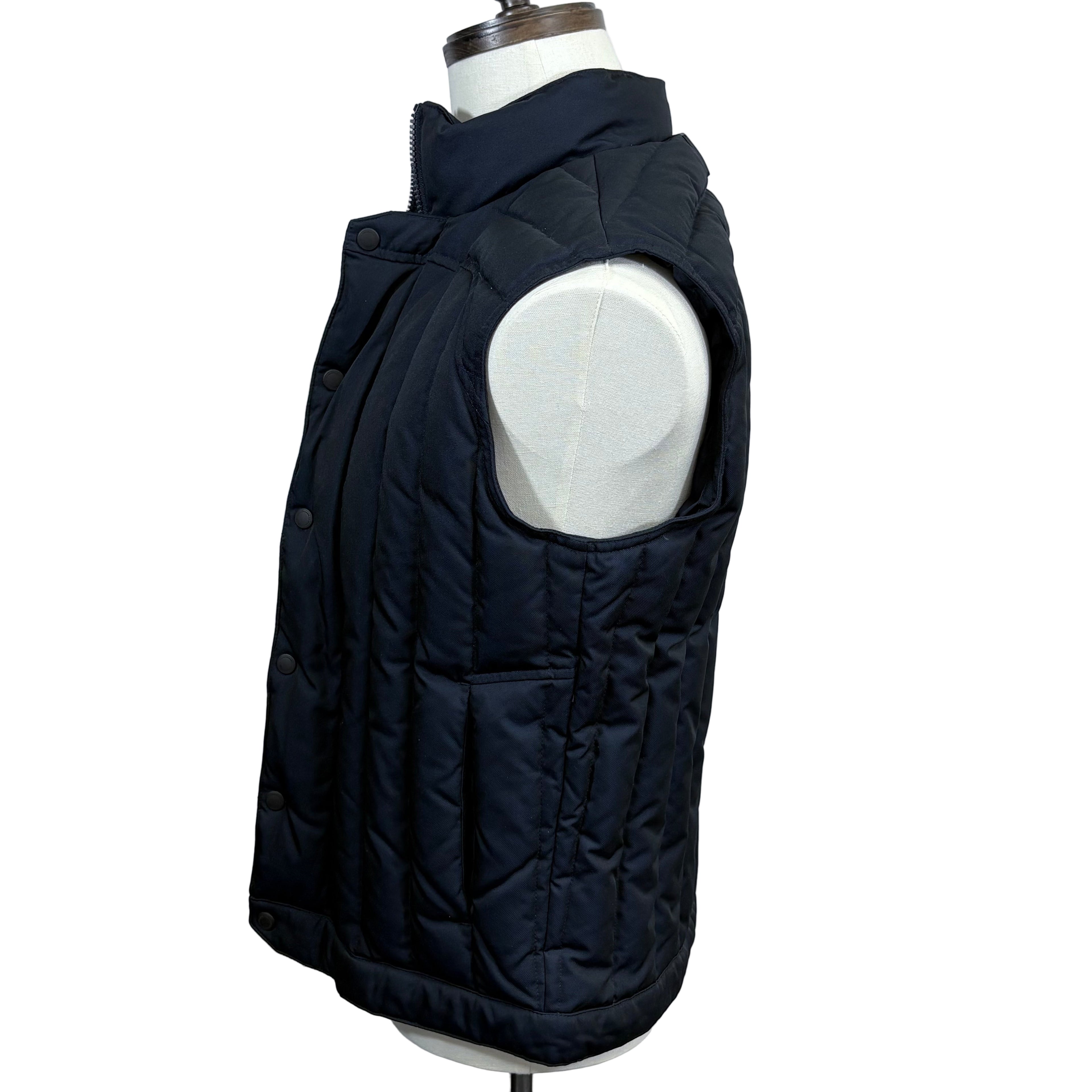 Black quilted vest on a mannequin against a gray background