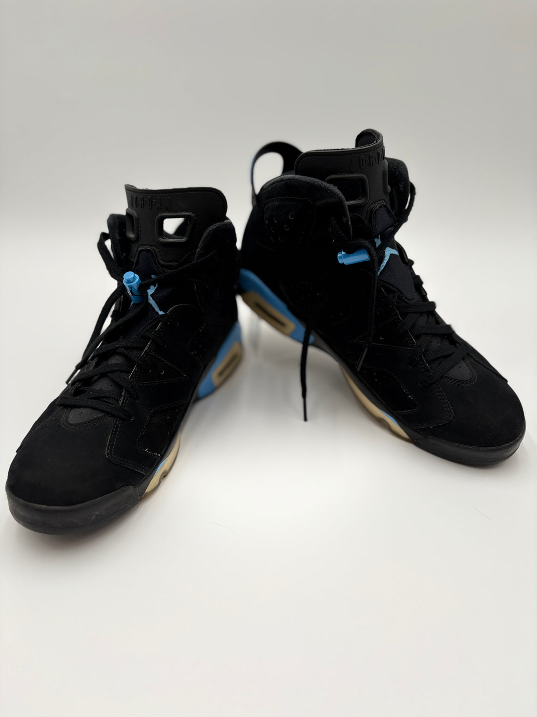 Black high-top sneakers with a certificate of authenticity on a white surface