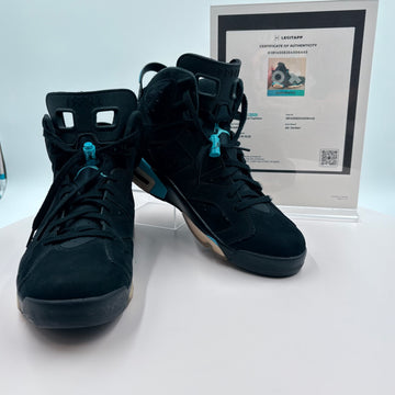 Black high-top sneakers with a certificate of authenticity on a white surface
