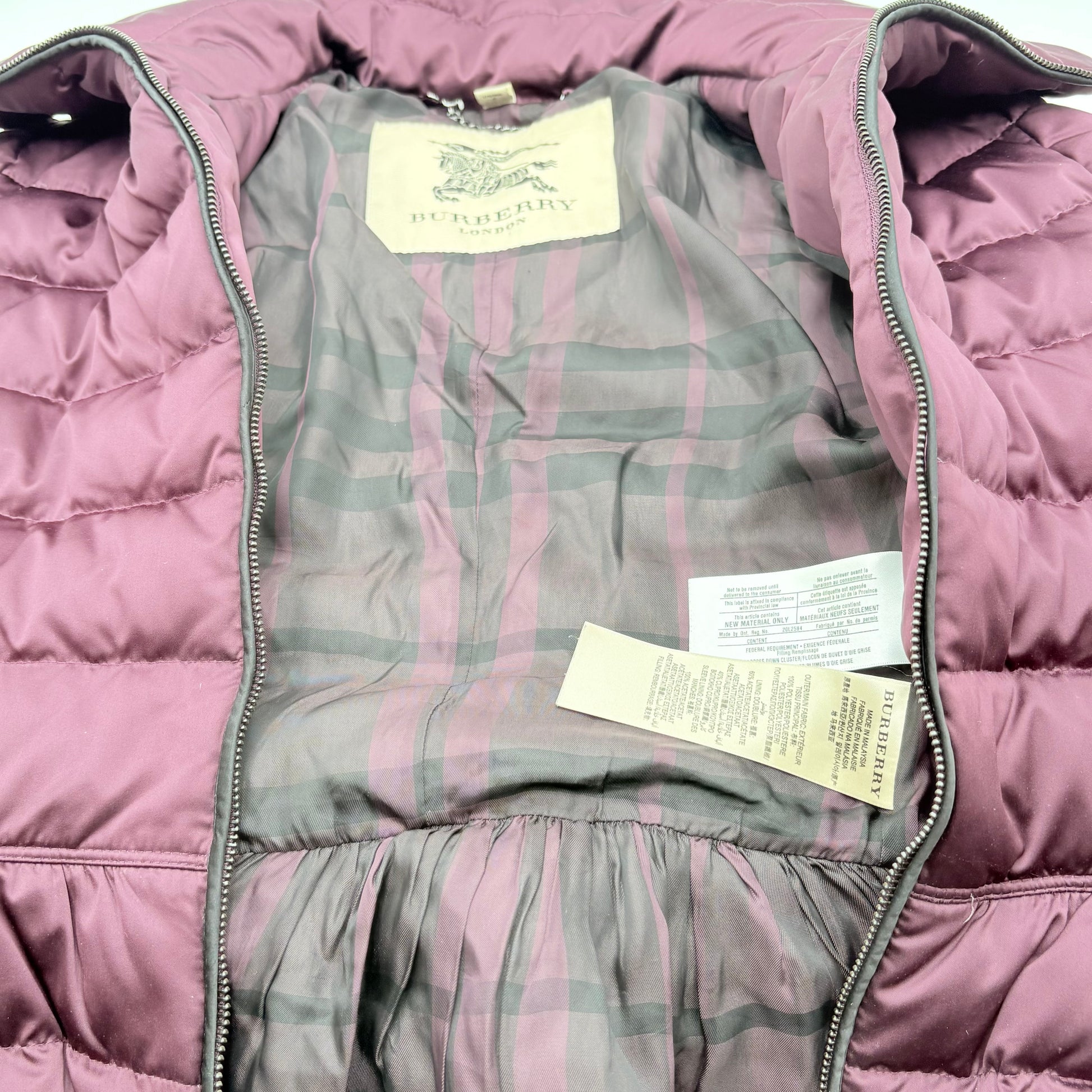 Purple puffer vest with tags inside, showing brand logo.