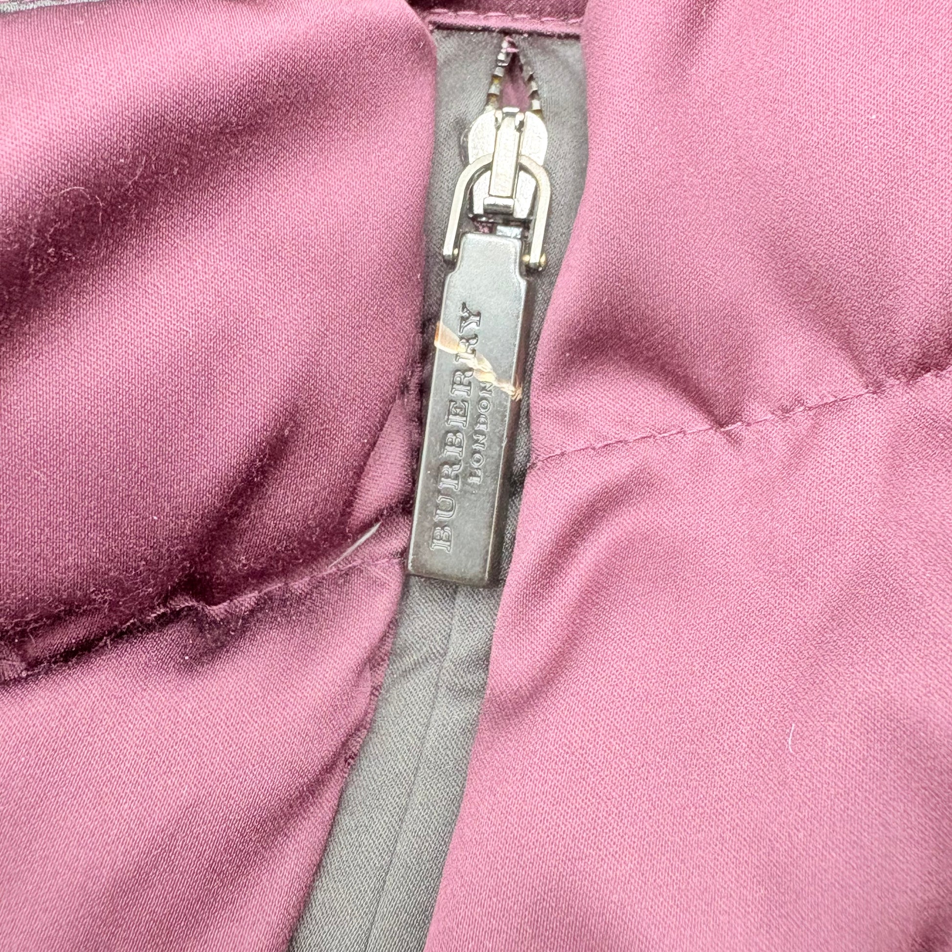 Close-up of a Burberry logo on a pink jacket zipper