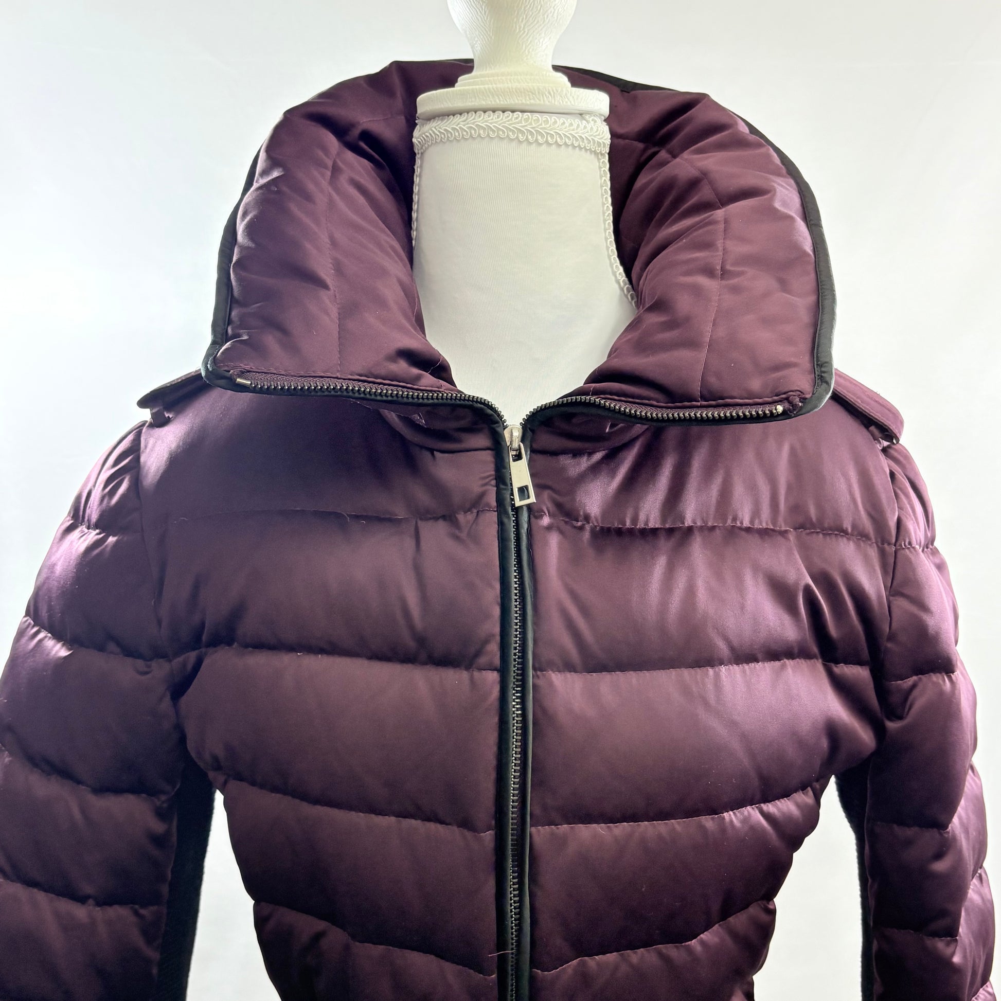Purple puffer jacket on a mannequin against a white background