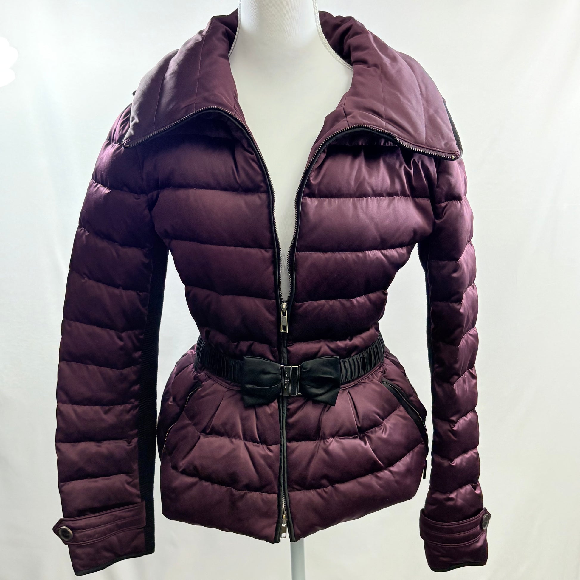 Purple puffer jacket on a mannequin against a white background