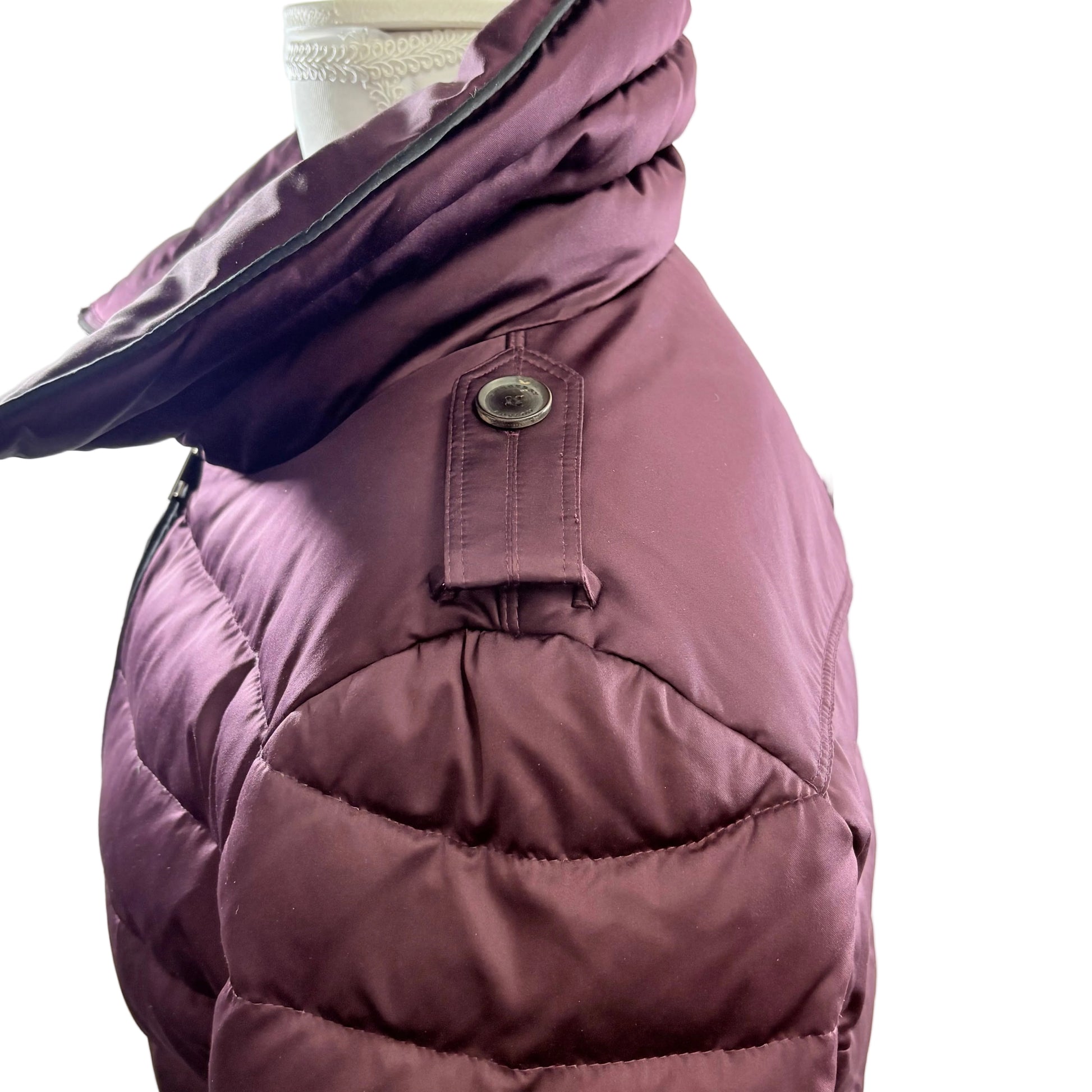 Purple puffer coat on a mannequin against a white background