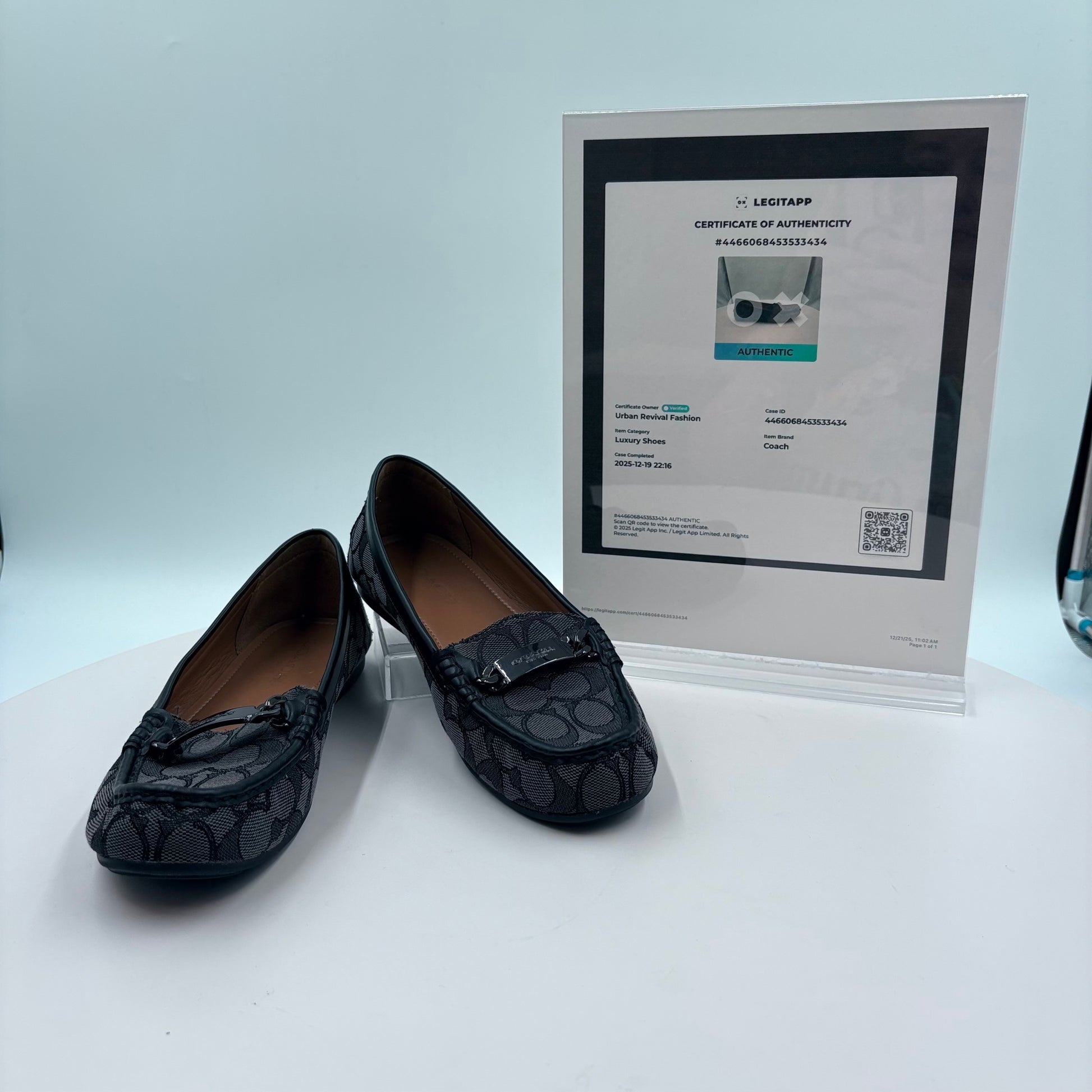 Black loafers with a certificate of authenticity on a white background