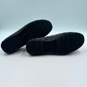 Black shoes shown from the sole on a light gray background