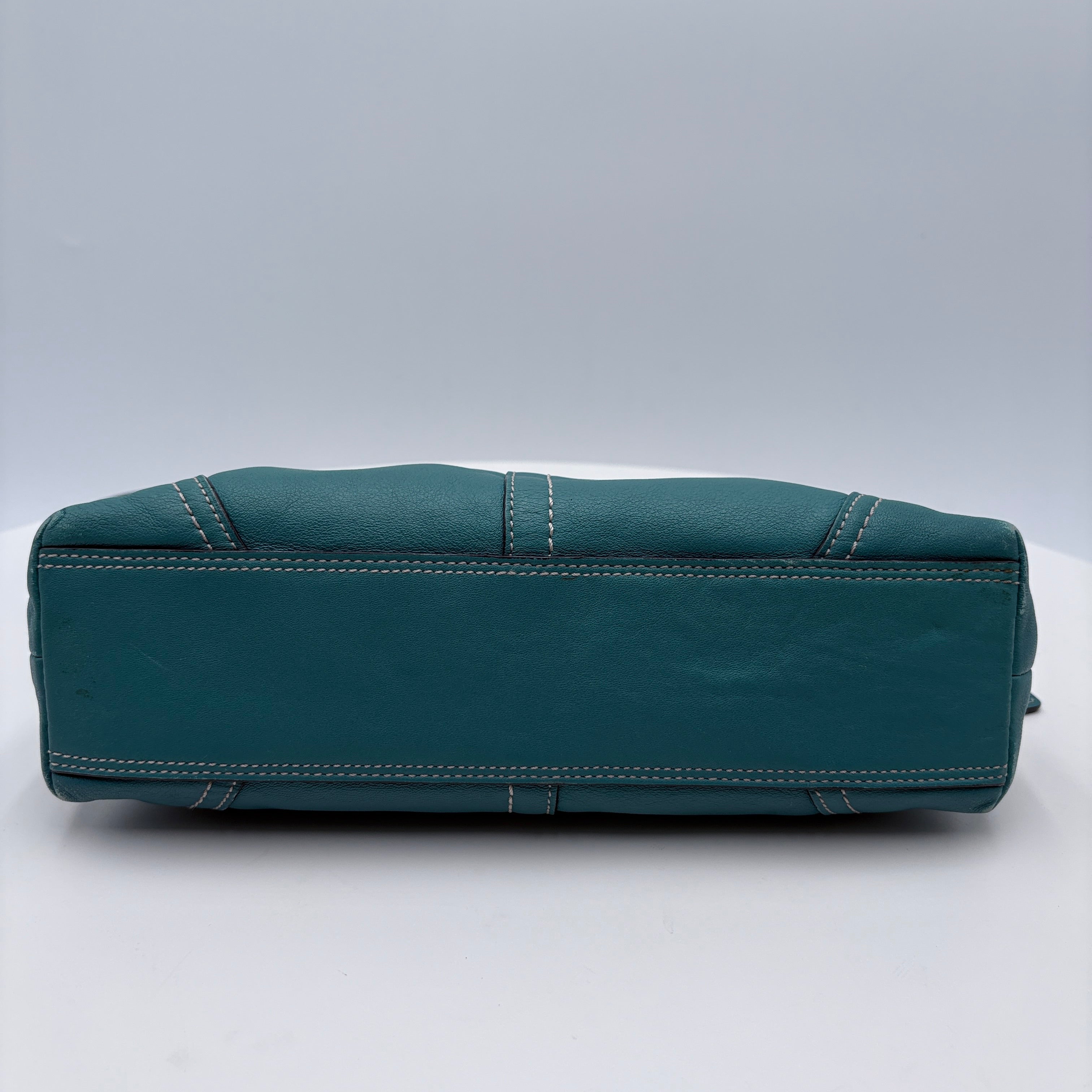 Teal leather bag on a white background