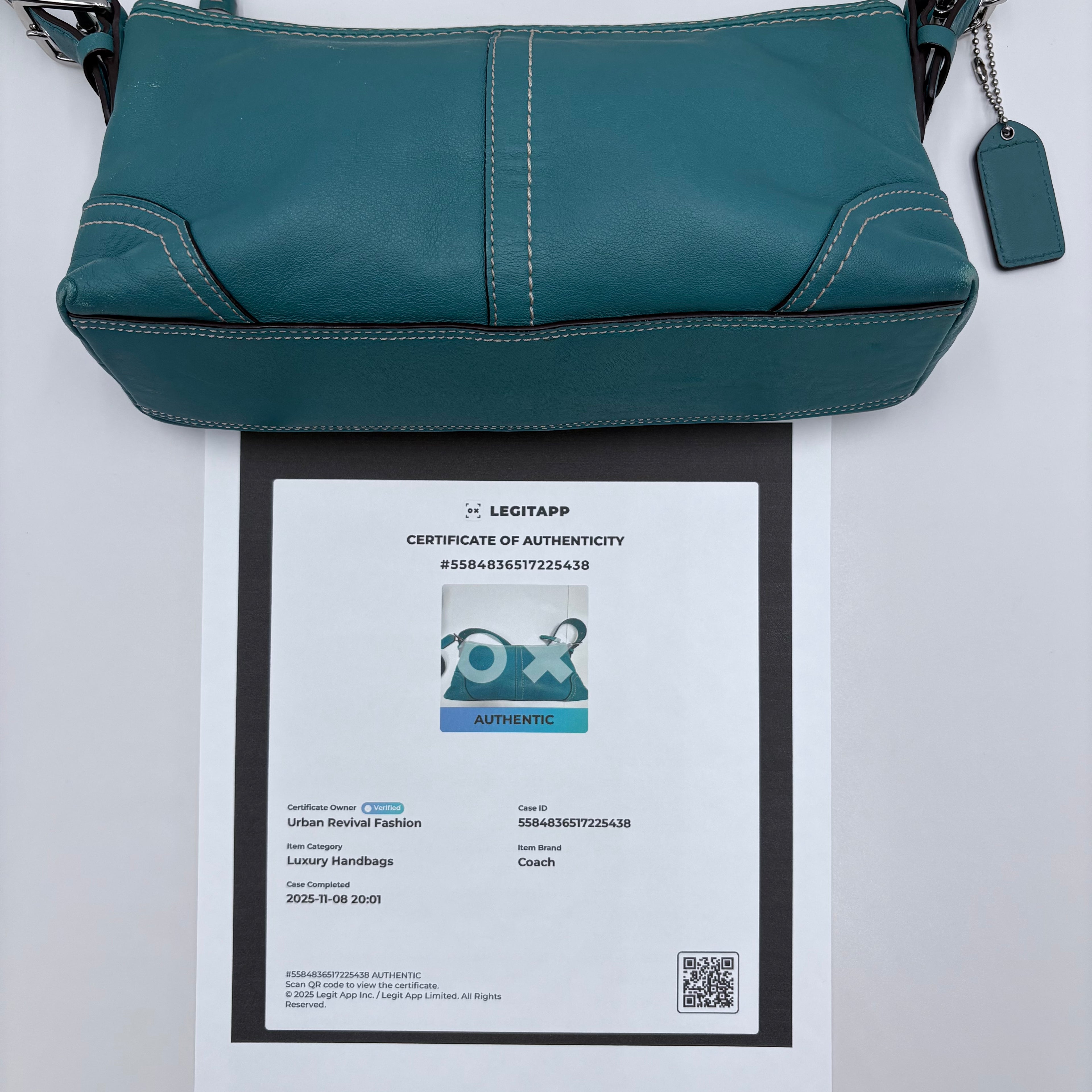 Teal handbag with a certificate of authenticity on a white background