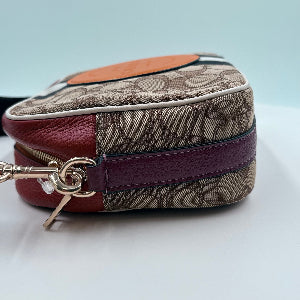 Coach bag with brown and purple pattern on a light gray background