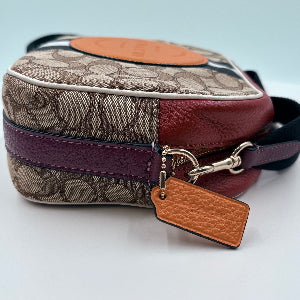 Patterned handbag with a brown tag on a light gray background