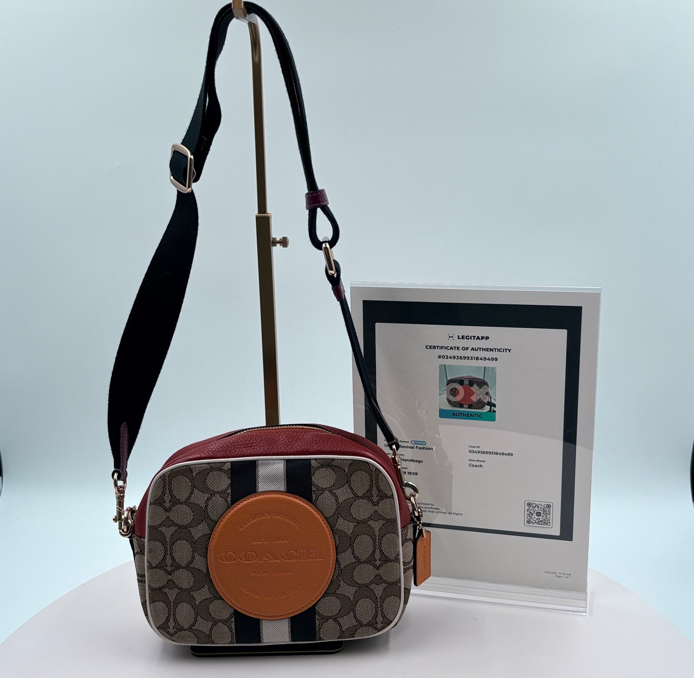 Designer handbag with a visible brand logo and a certificate of authenticity in the background.