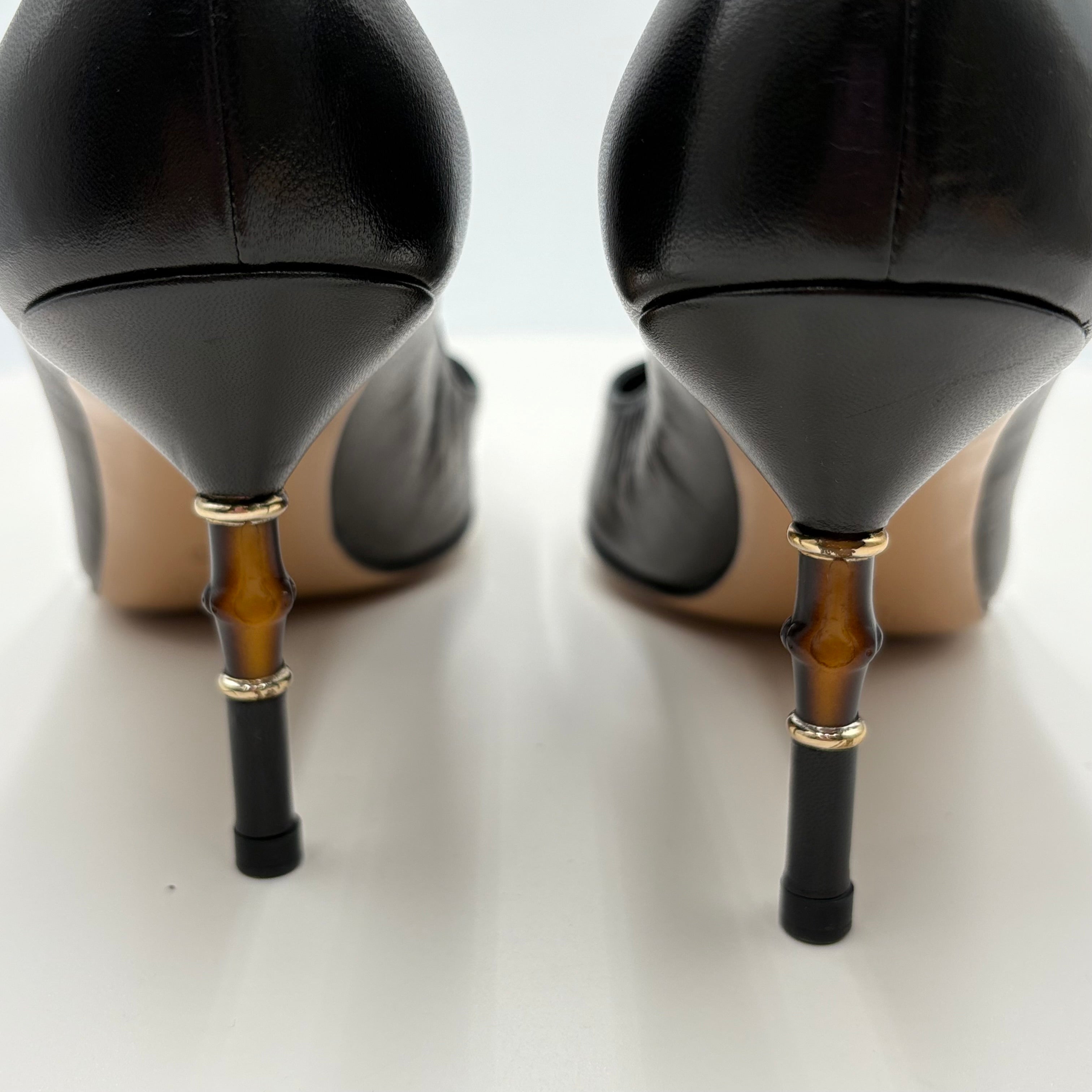 Black high-heeled shoes with unique bamboo-style heel designs on a white background
