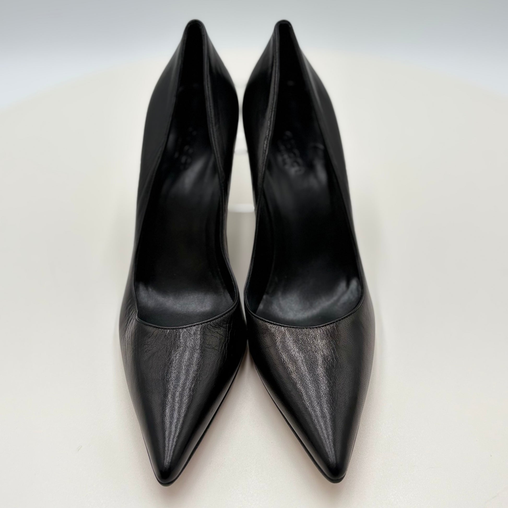 Pair of black high-heeled shoes on a light gray background