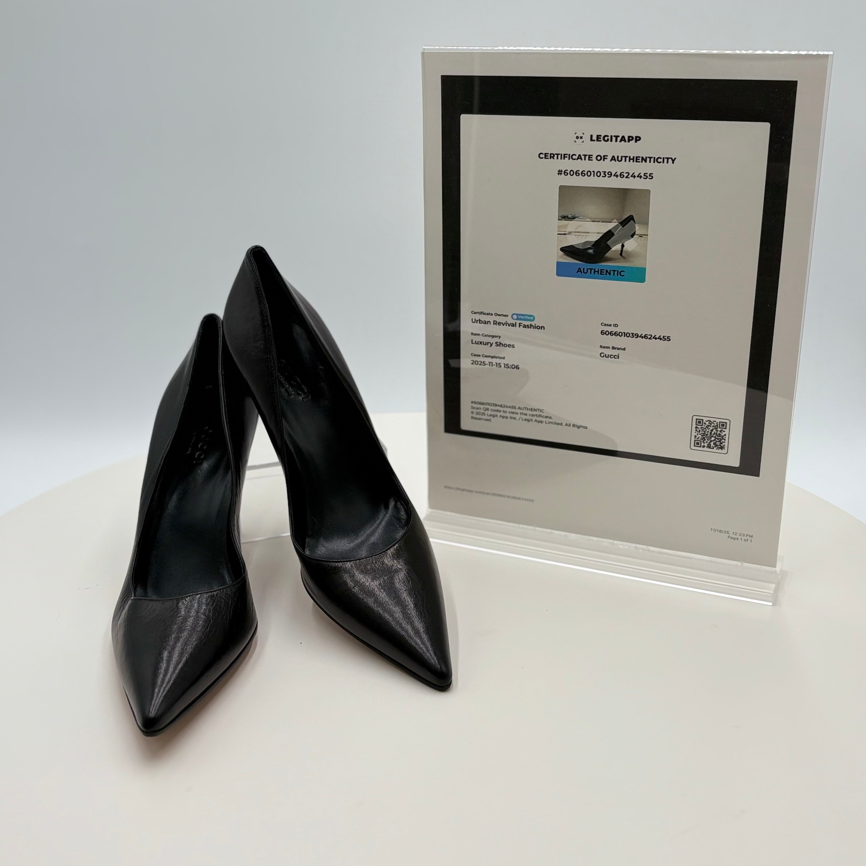 Black high-heeled shoes with a certificate of authenticity on a white background