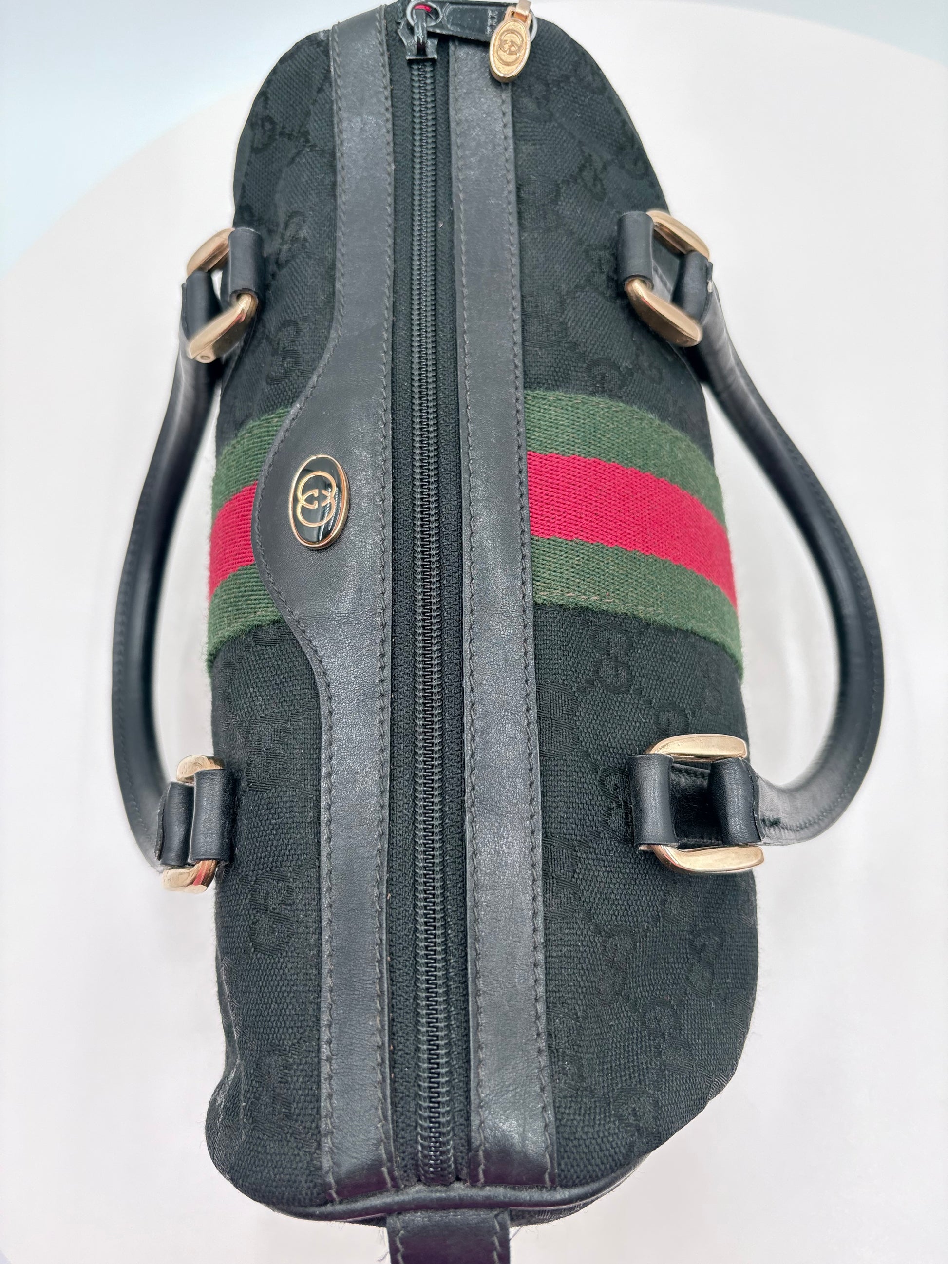Black handbag with red and green stripes on a white background