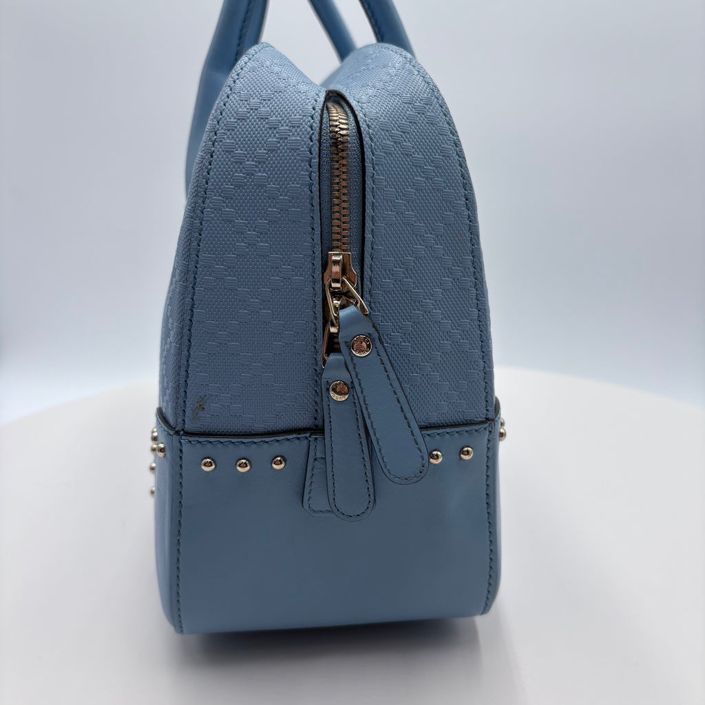 Blue backpack with gold accents on a light gray background