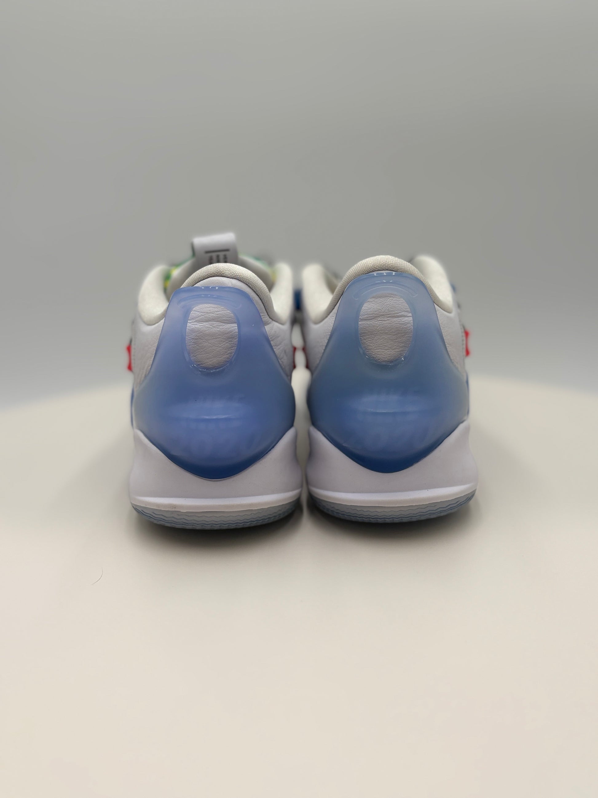 White sneakers with blue soles on a light gray background