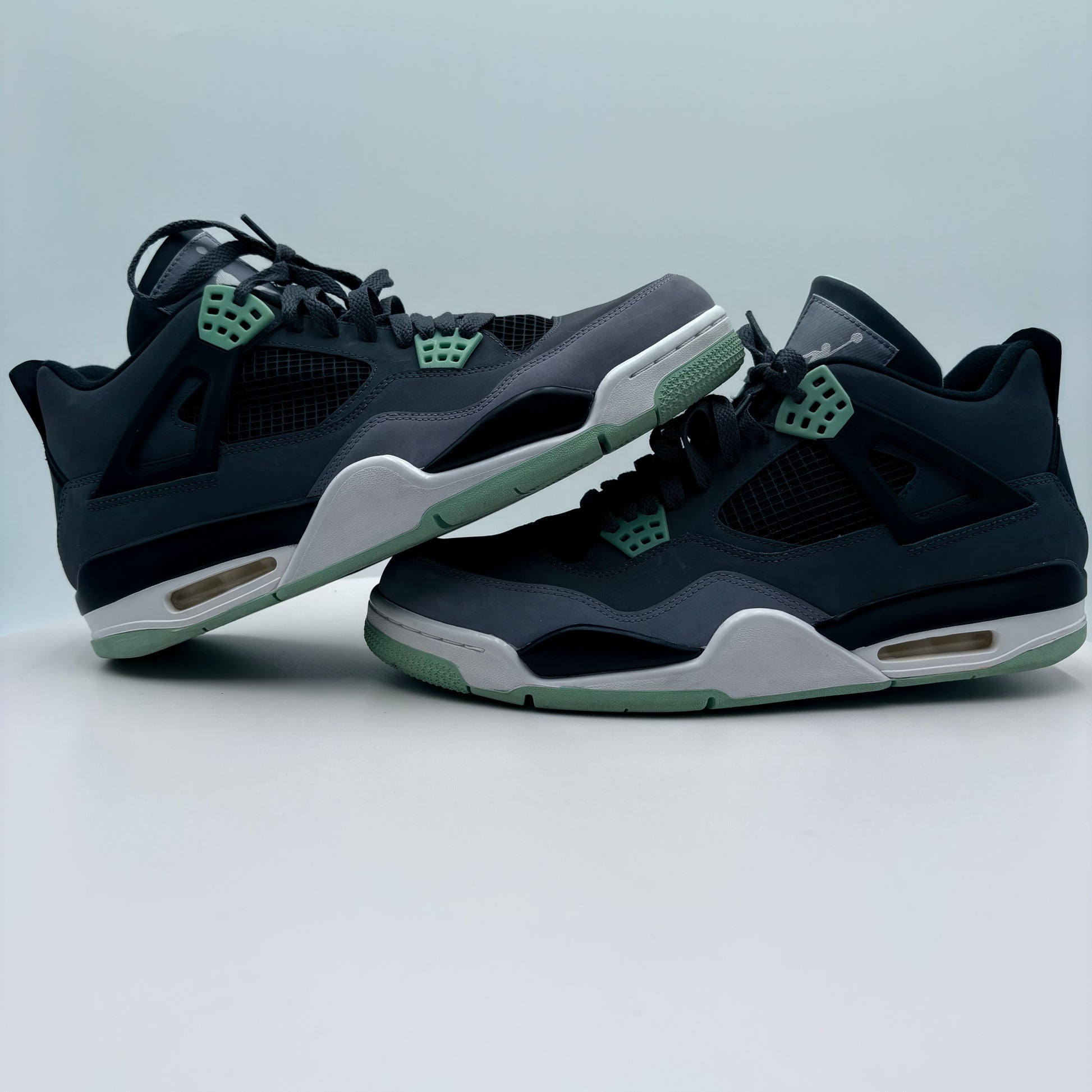 Pair of black and green sneakers on a light gray background