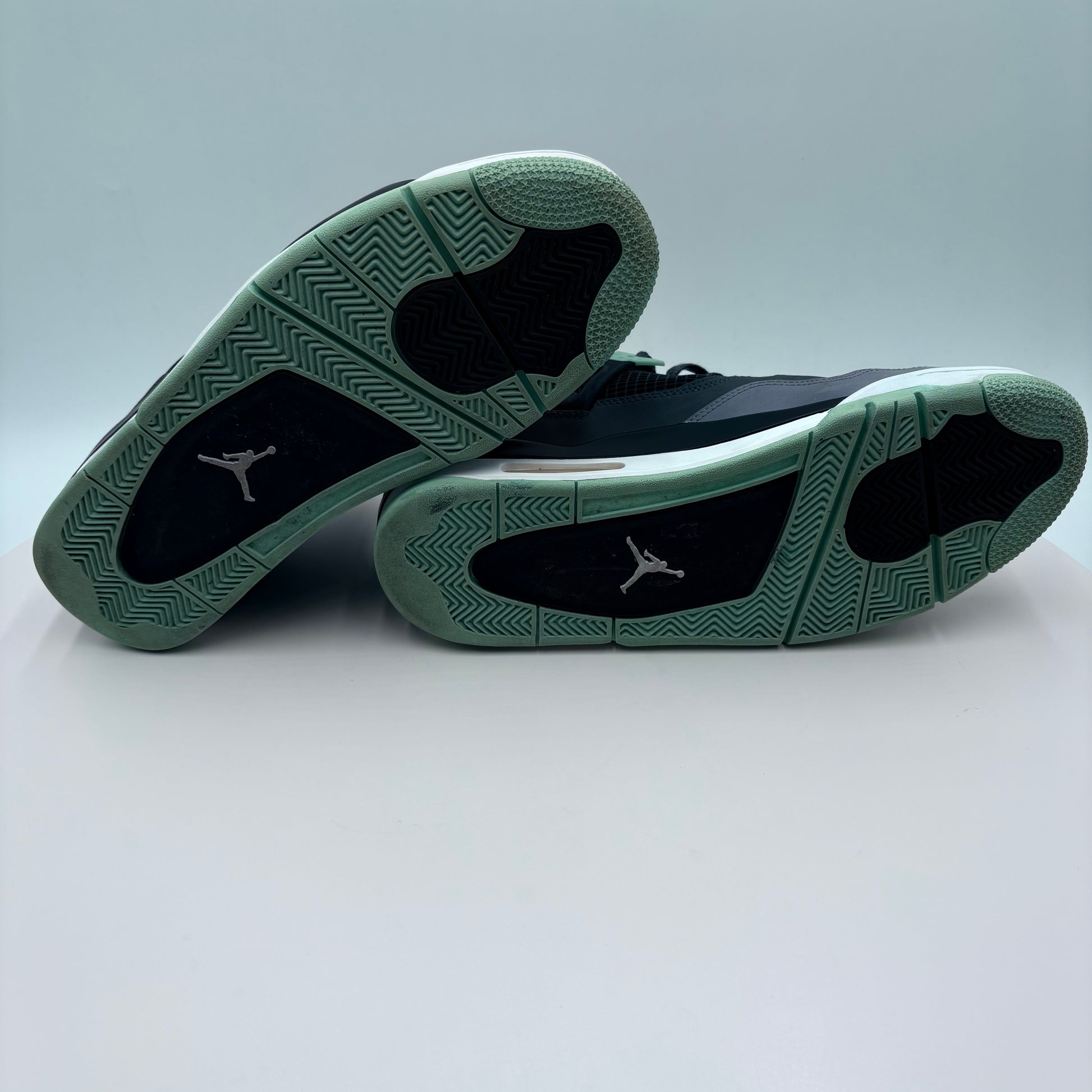 Pair of black and green sneakers on a light gray background