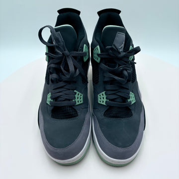Pair of dark blue Nike sneakers with green accents on a light gray background