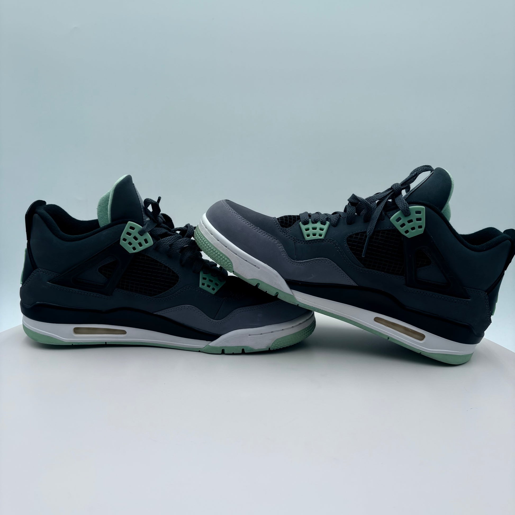 Pair of black and gray sneakers with green accents on a light gray background