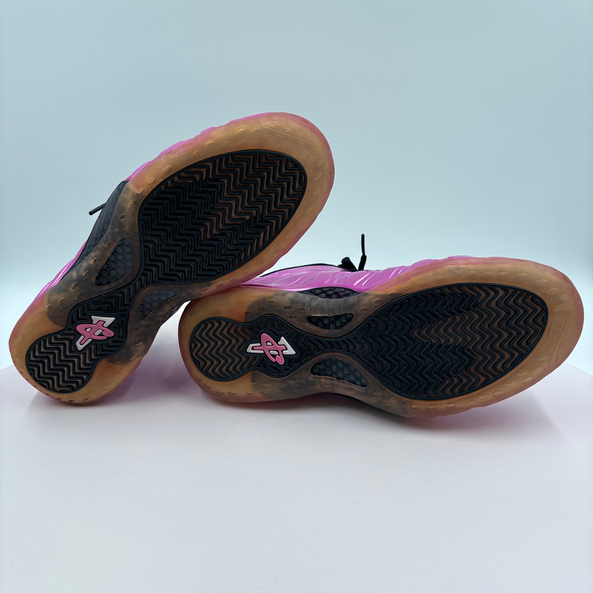 Pink and brown sneakers with a brand logo on a white background