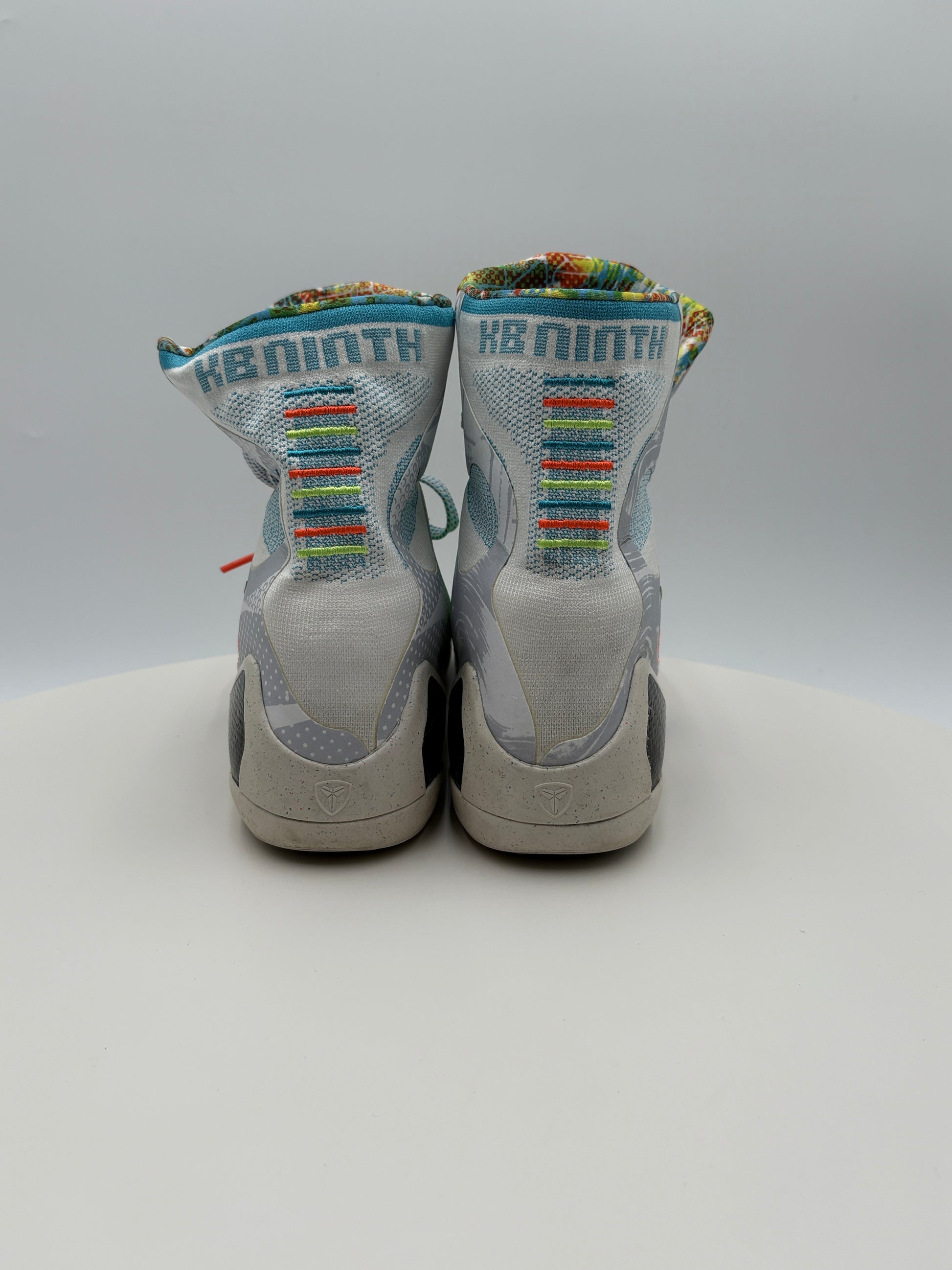 Pair of white sneakers with colorful text on a light gray background