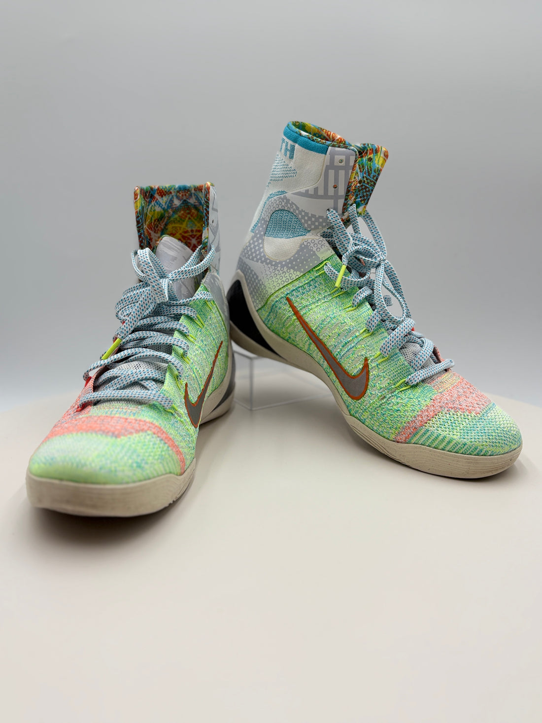 Colorful high-top sneakers on a white surface with a certificate underneath