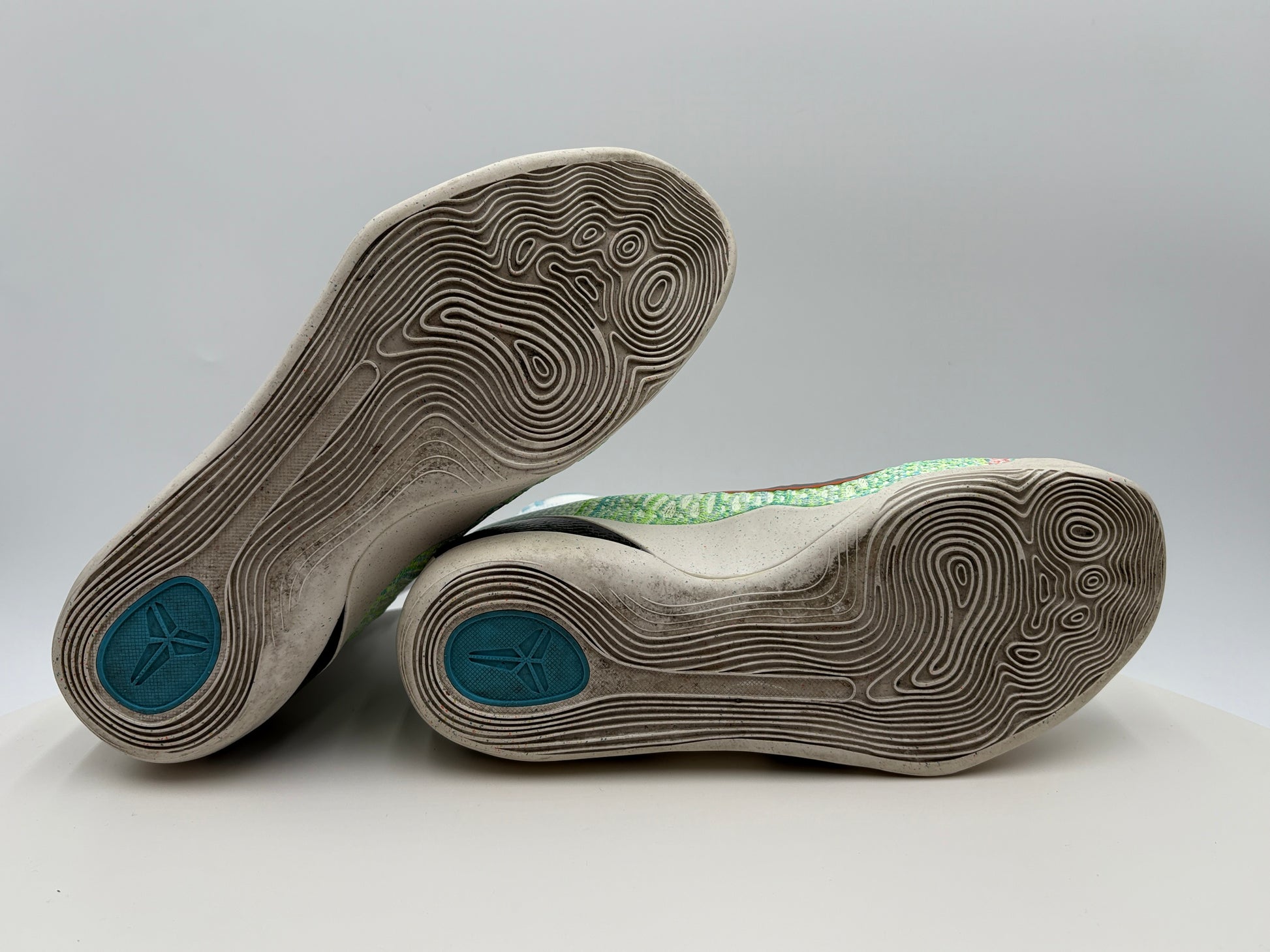 Close-up of a pair of shoes with tread pattern on a gray background