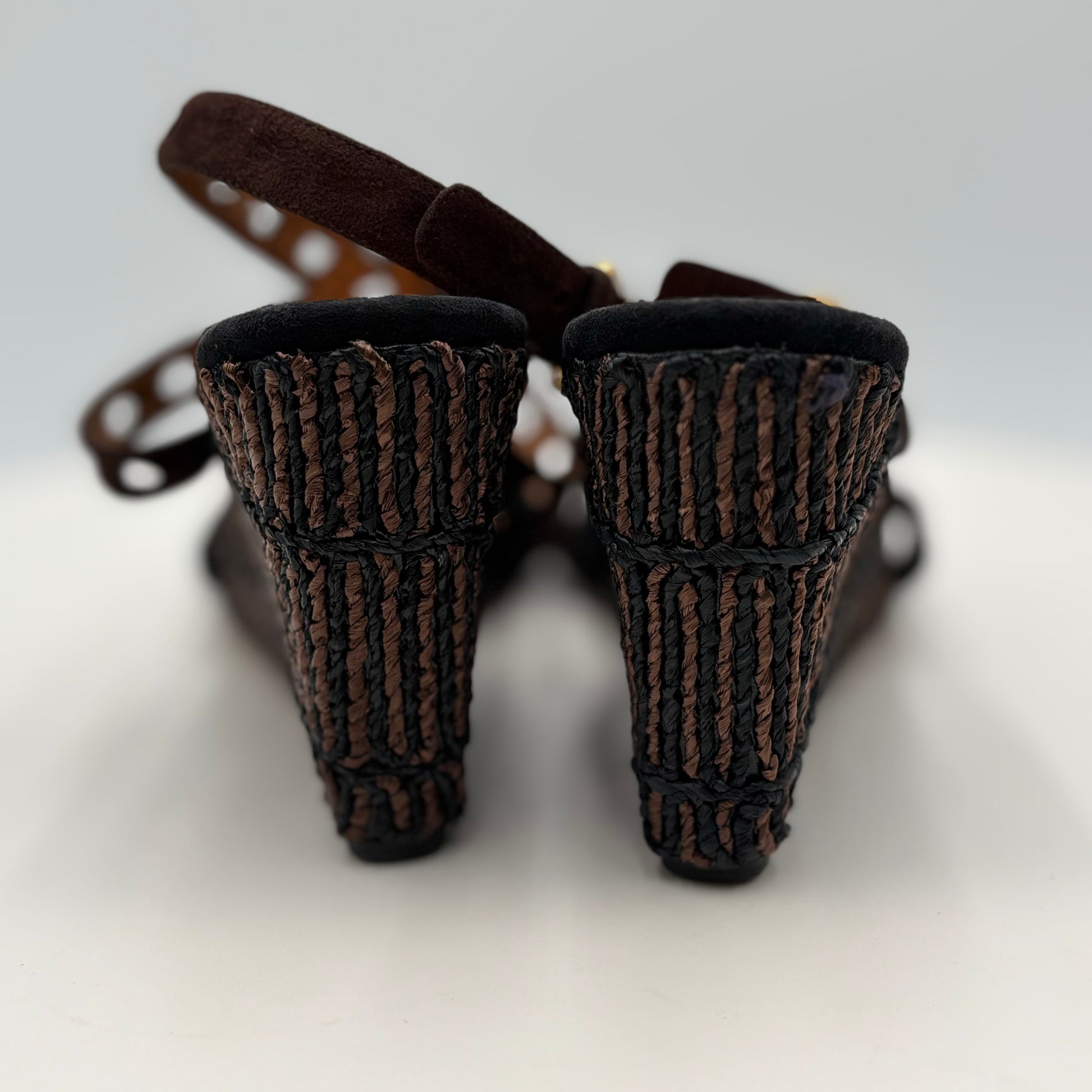 Pair of brown high-heeled shoes with textured design on a light gray background