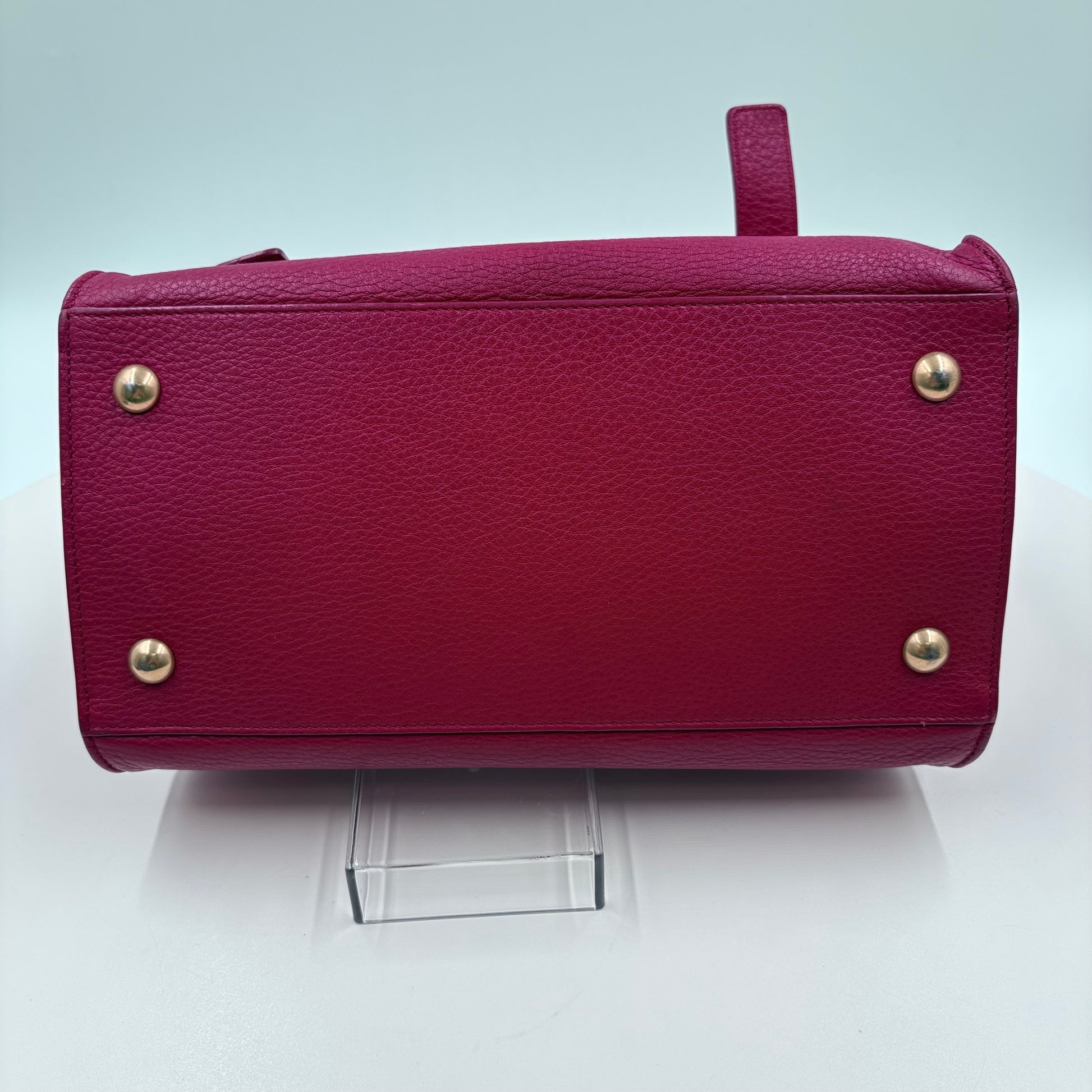 Red handbag with gold studs on a white background