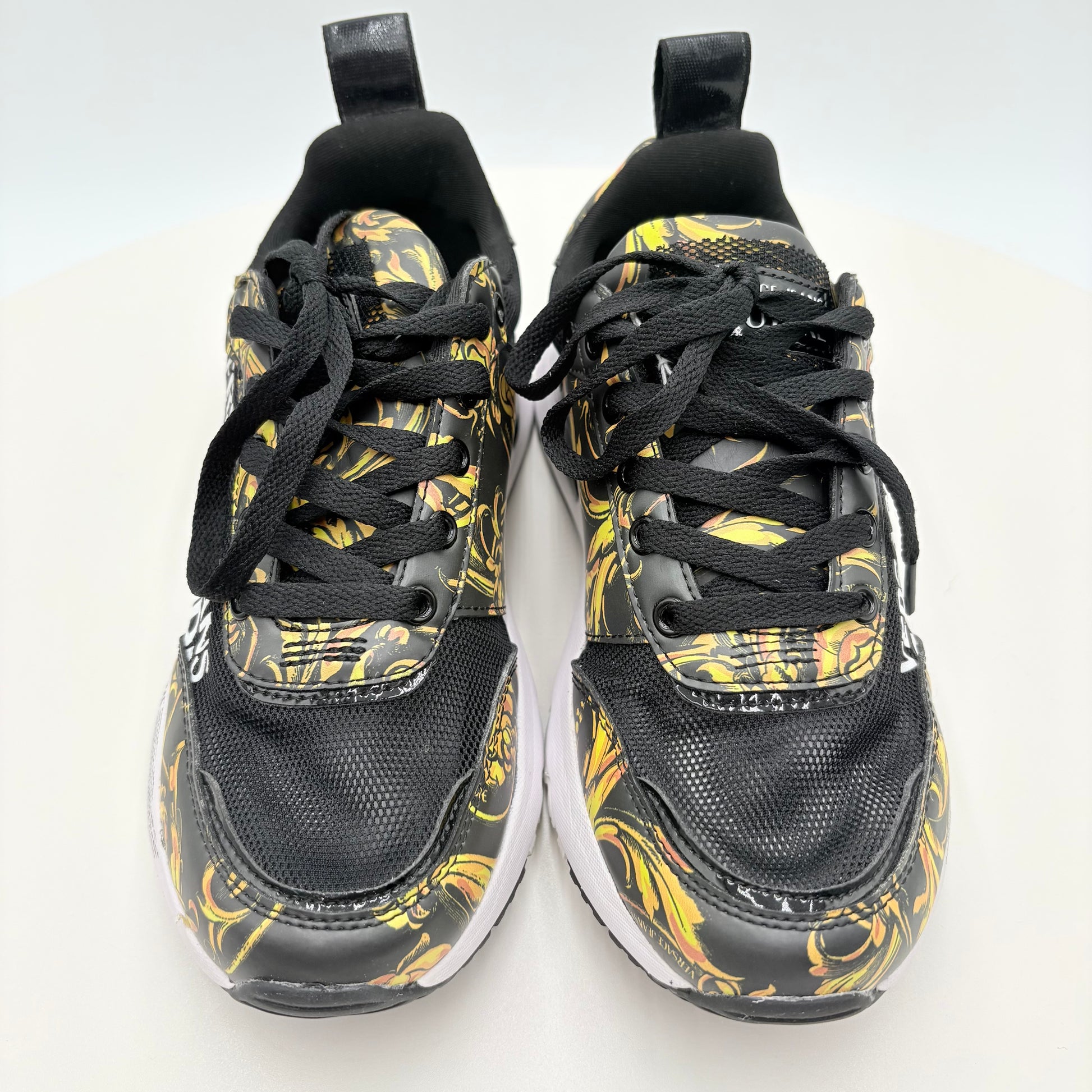 Black and yellow patterned sneakers on a white background