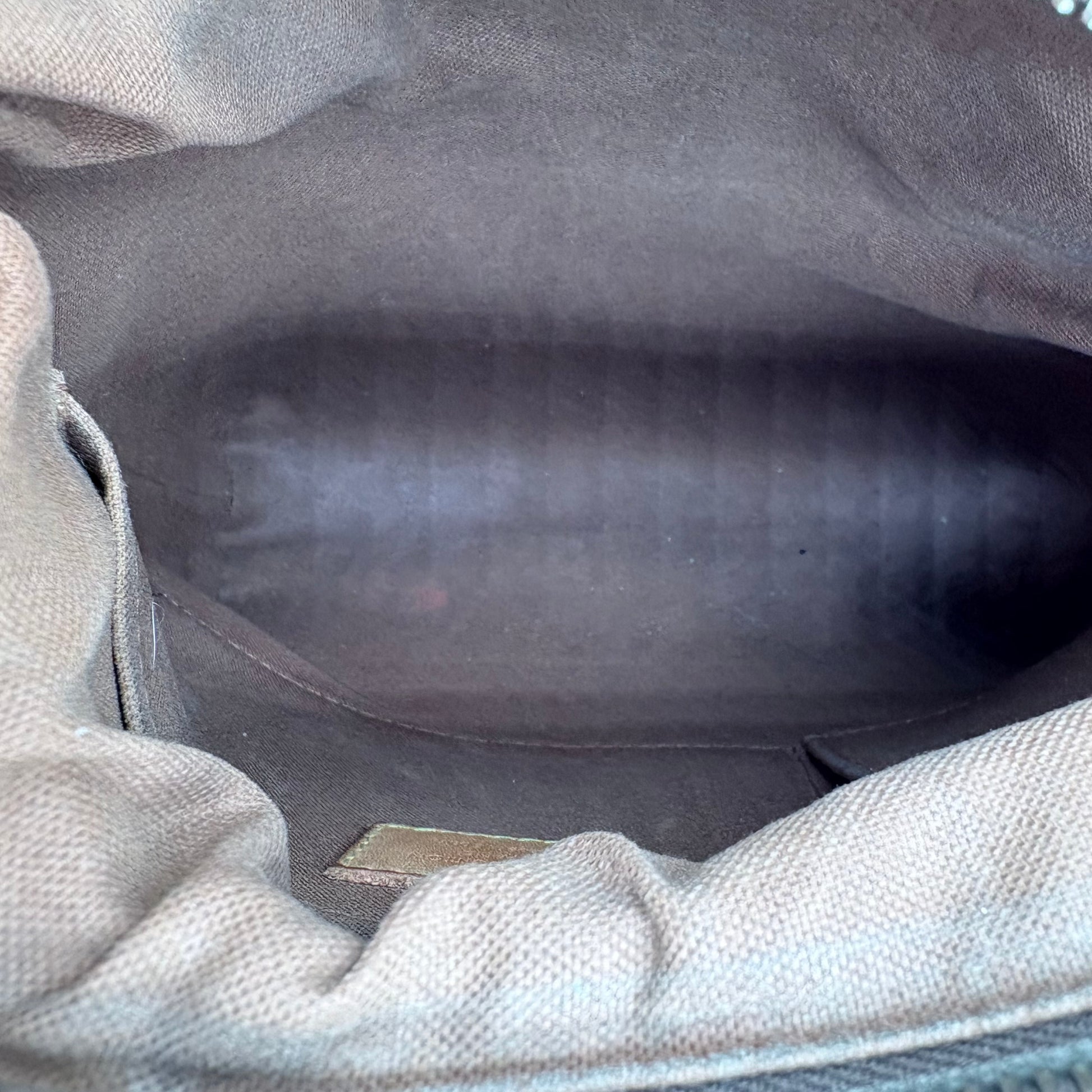 Close-up of a textured gray fabric surface with a visible brand logo.