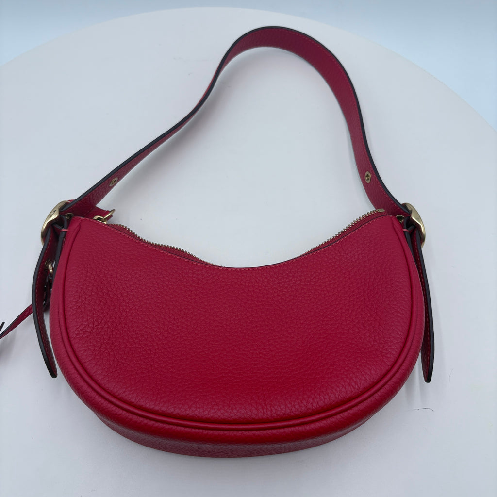 Red handbag with a strap on a white background