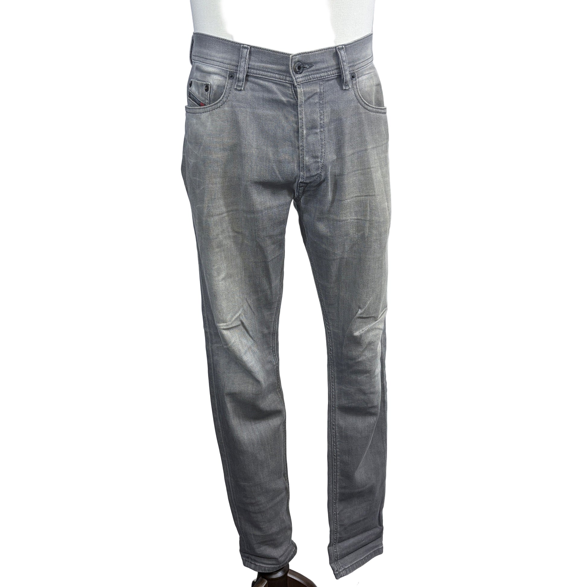 Gray jeans on a mannequin against a plain background