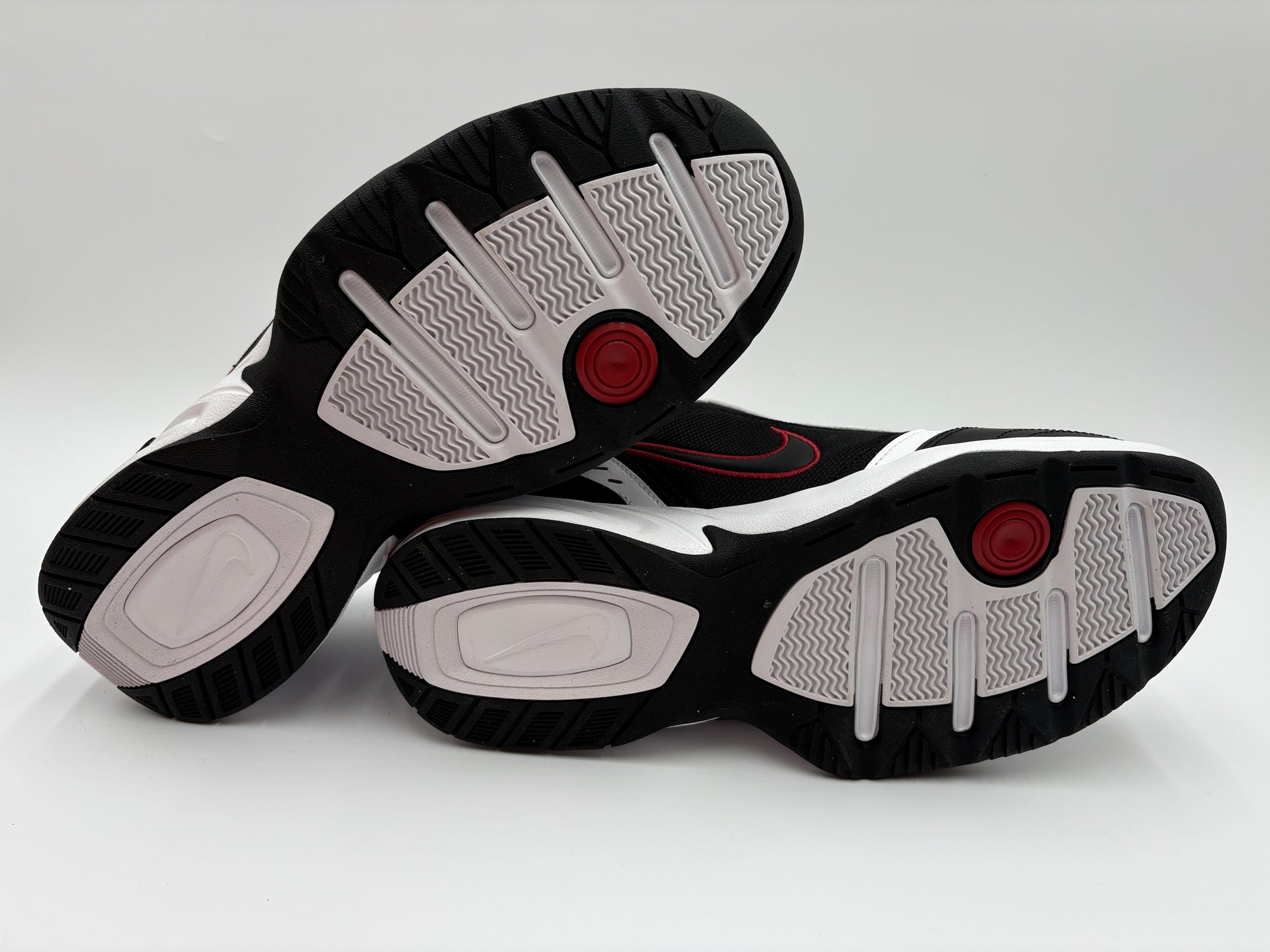 Black and white sneakers with red accents on a light gray background