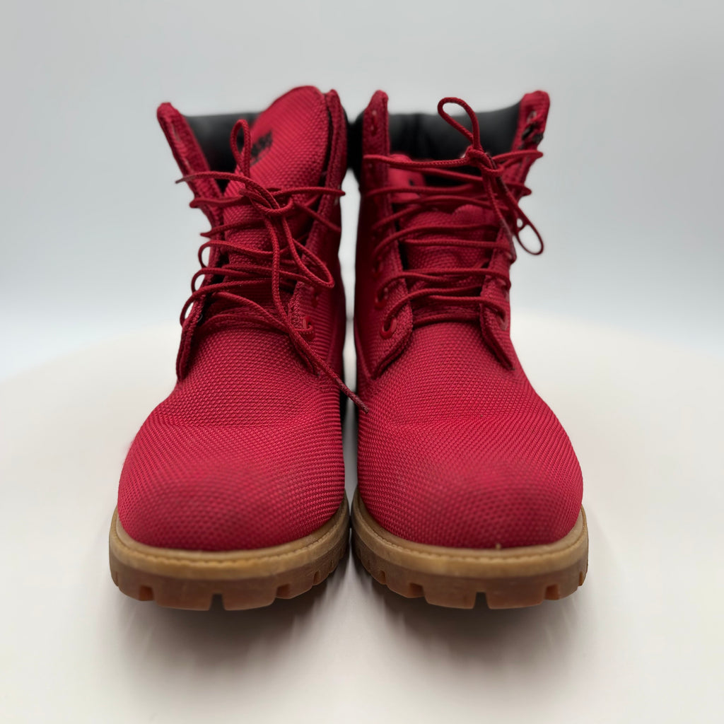 Pair of red boots with brown soles on a white background