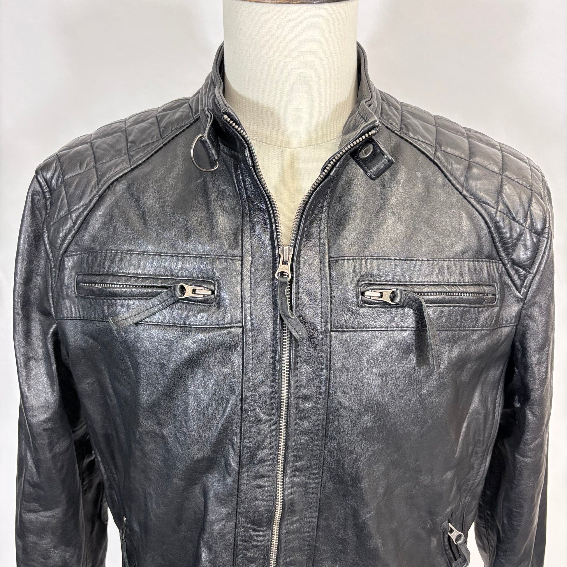 Gray leather jacket on a mannequin against a white background