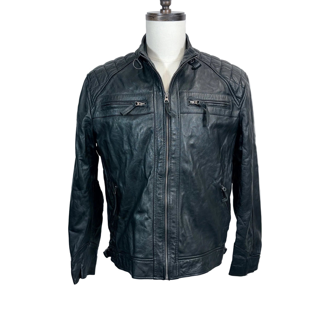 Black leather jacket on a mannequin against a white background