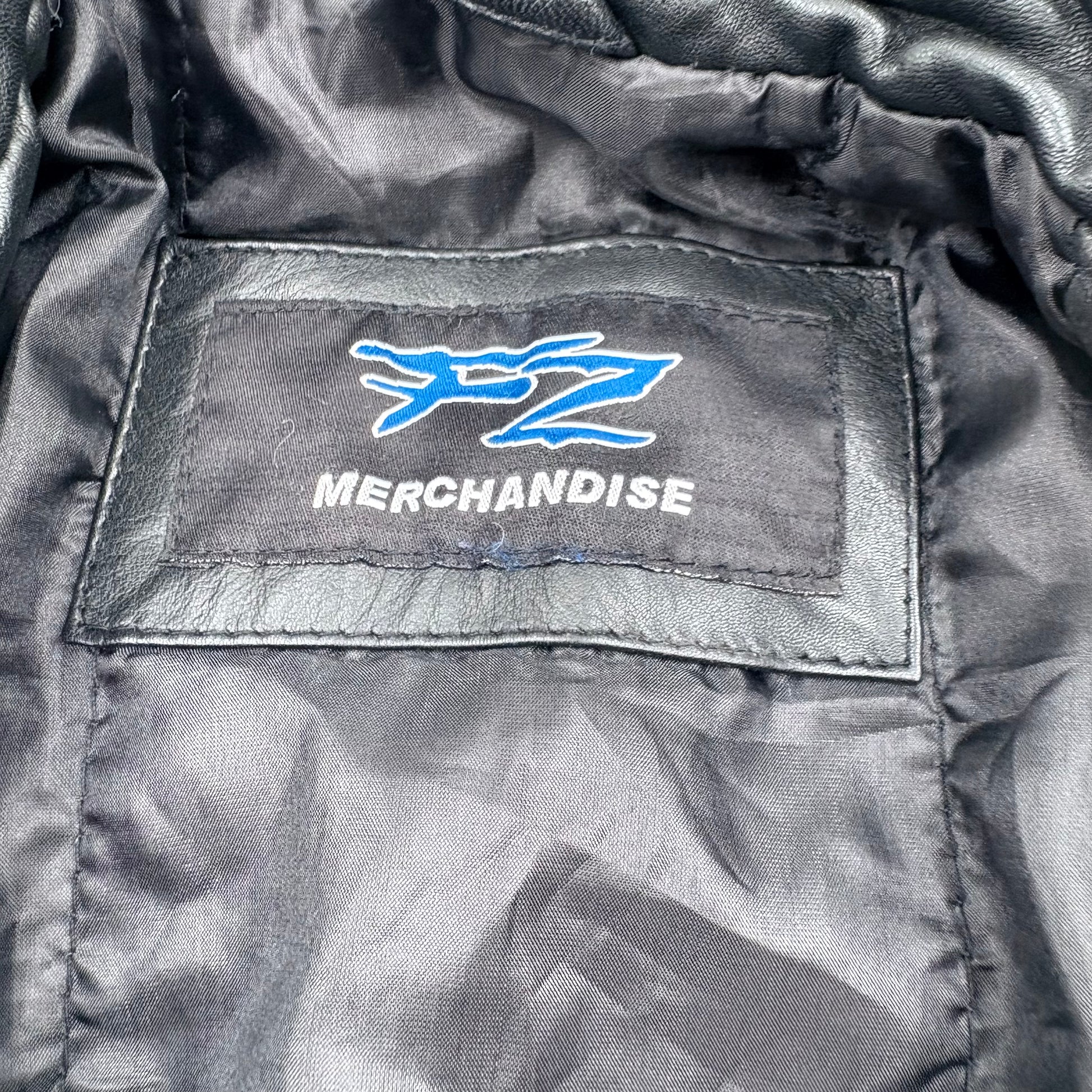 Close-up of a merchandise label on a jacket with a logo and text.