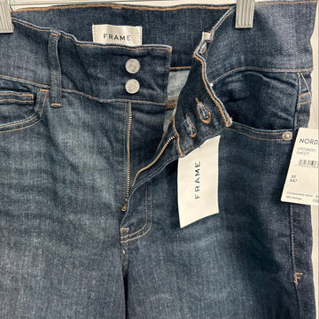 Pair of blue jeans with Frame and Nordstrom tags on a white background